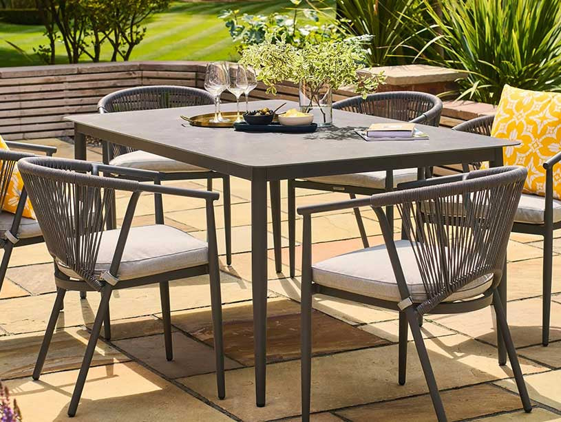 Aluminium 6-seater garden table and chairs in dark grey on a patio