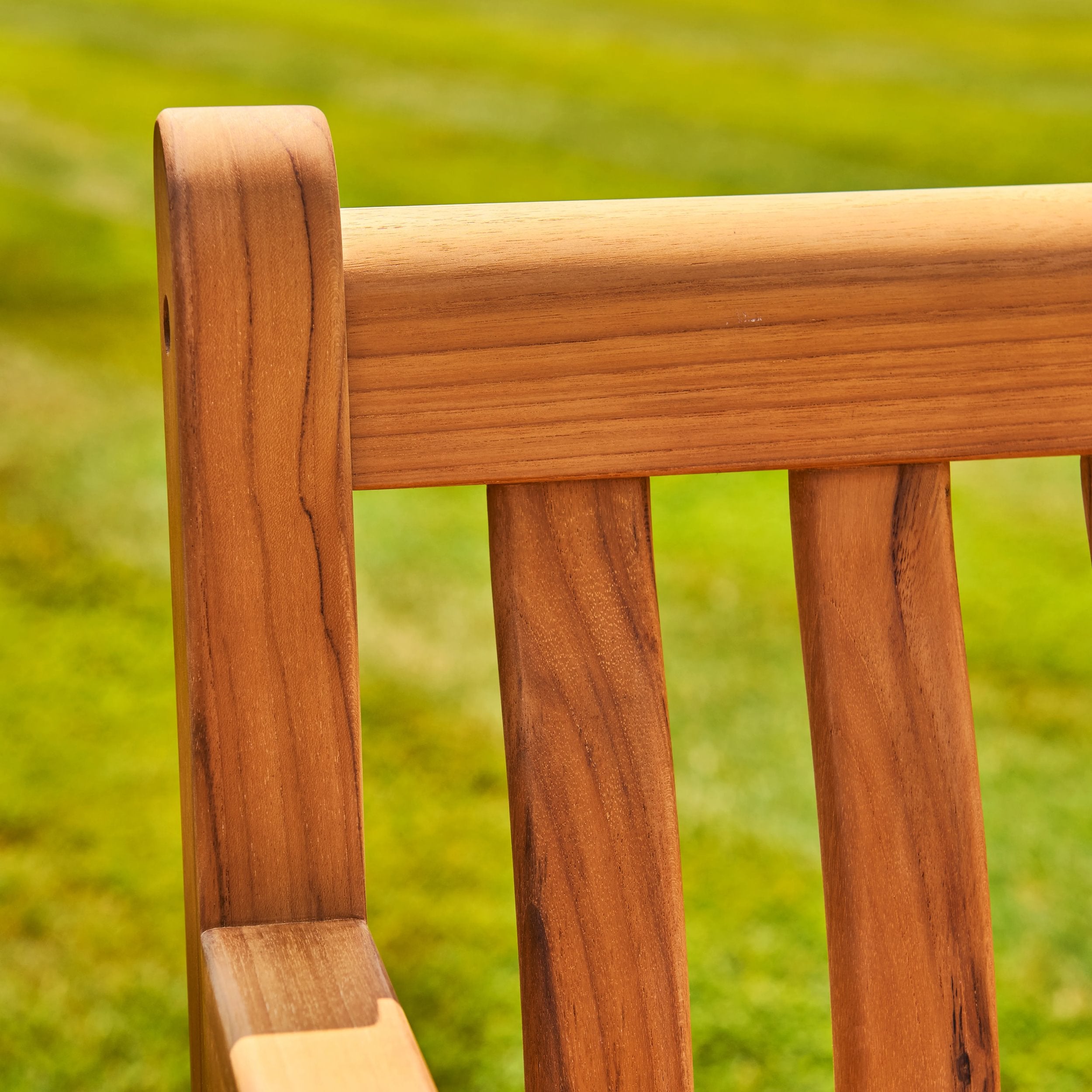 Close-up of a wooden chair with a blurred green background