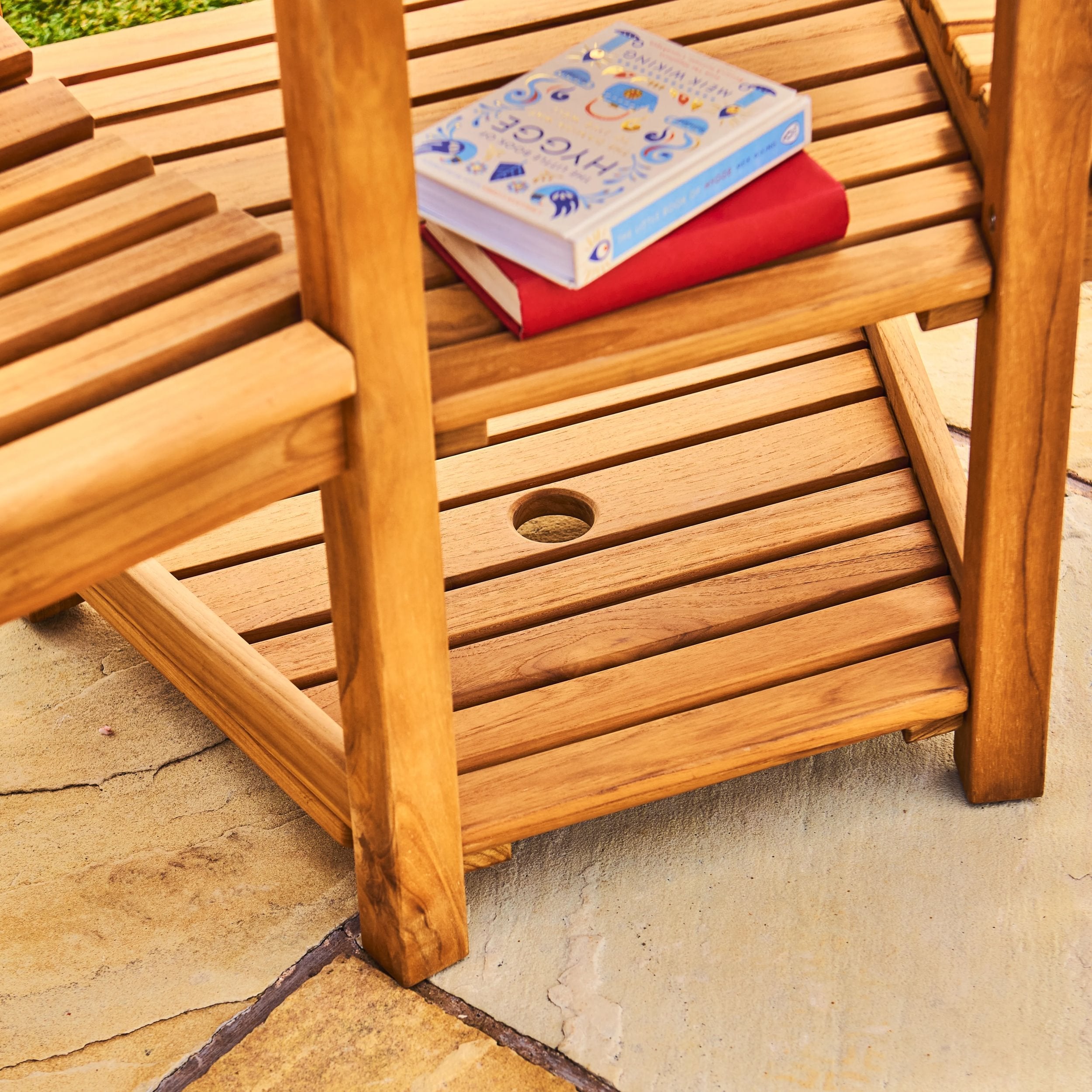 Wooden side table with books on a stone patio