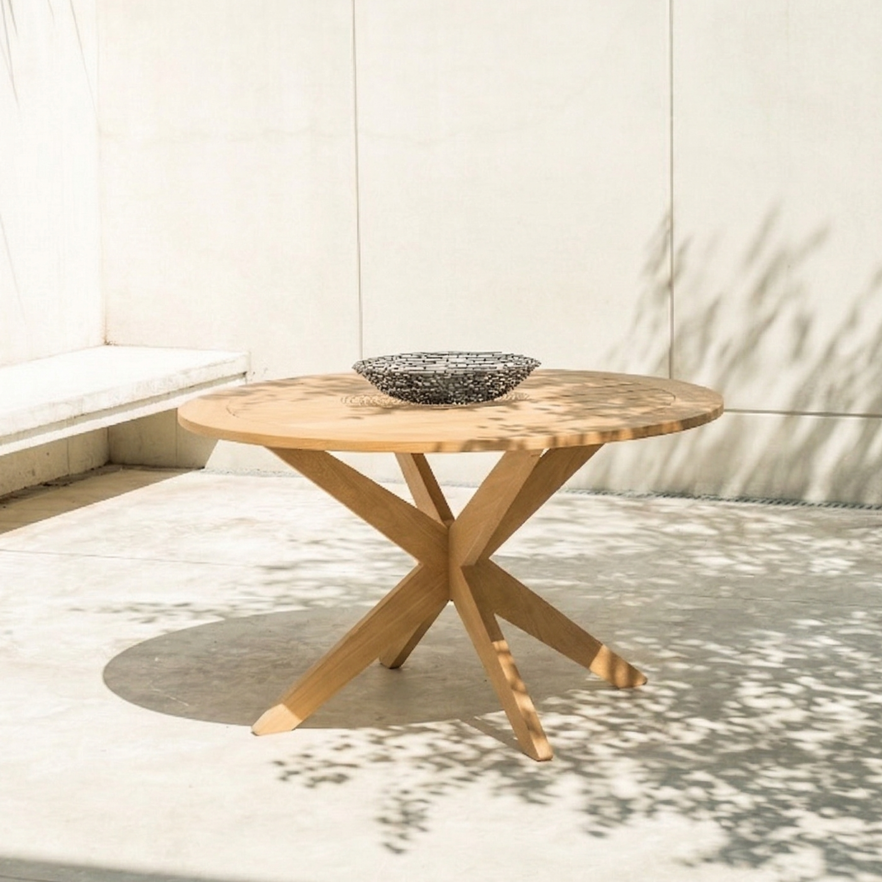 circular dining table with star-shaped legs on a patio