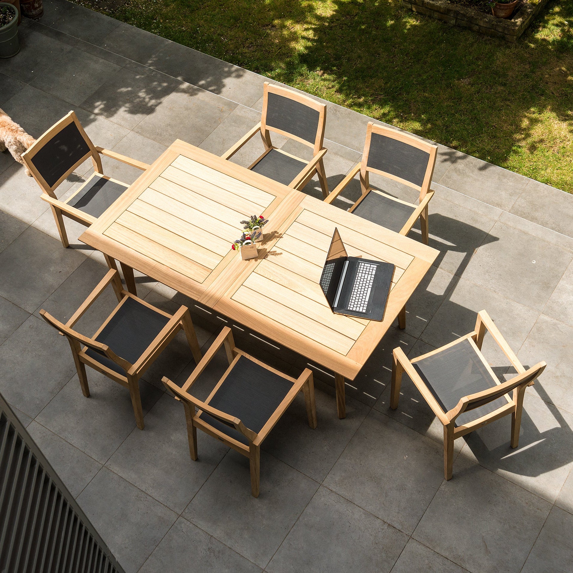 Extending rectangular roble wood table and 6 dining armchairs with fabric backs and seats in dark grey