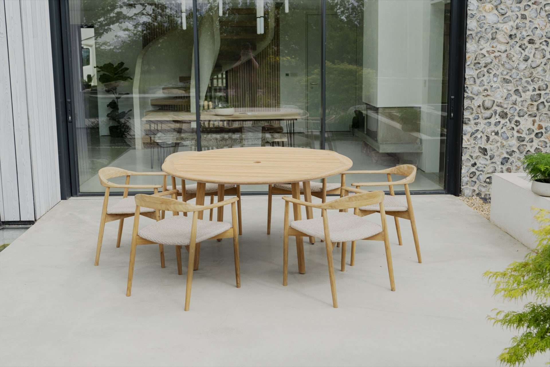Outdoor dining set with wooden table and chairs on a patio.