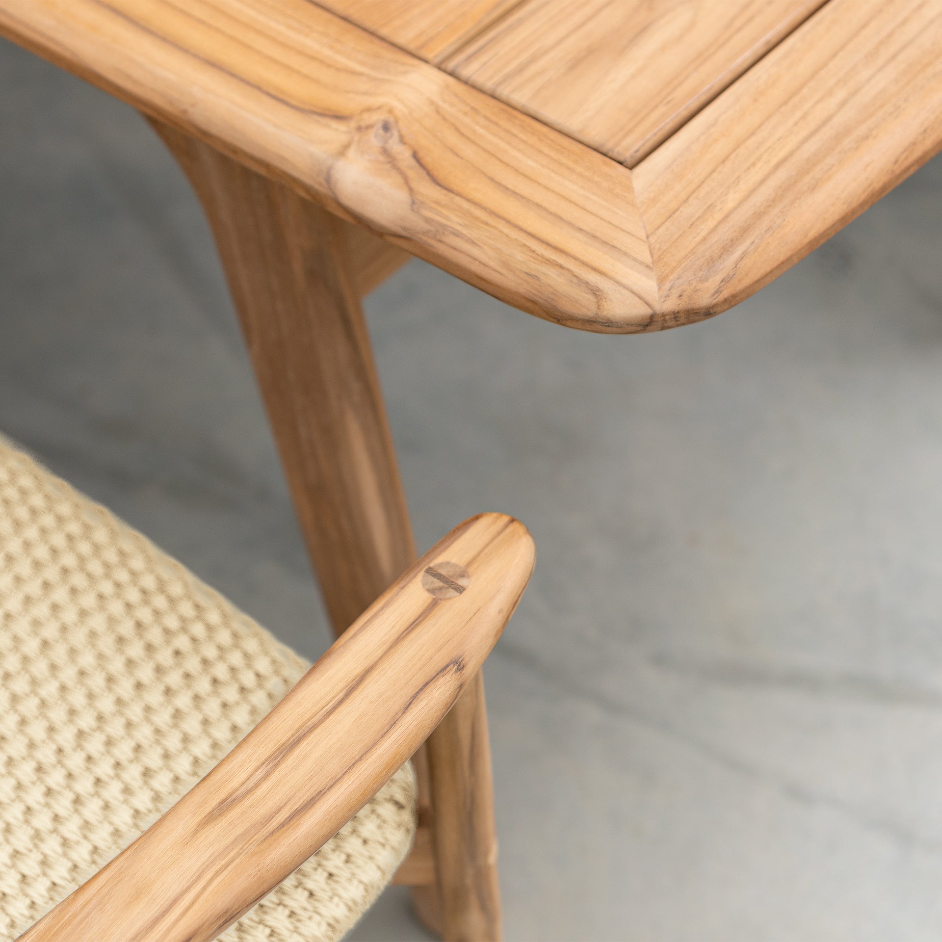 Close-up of a wooden chair with a woven seat on a neutral background