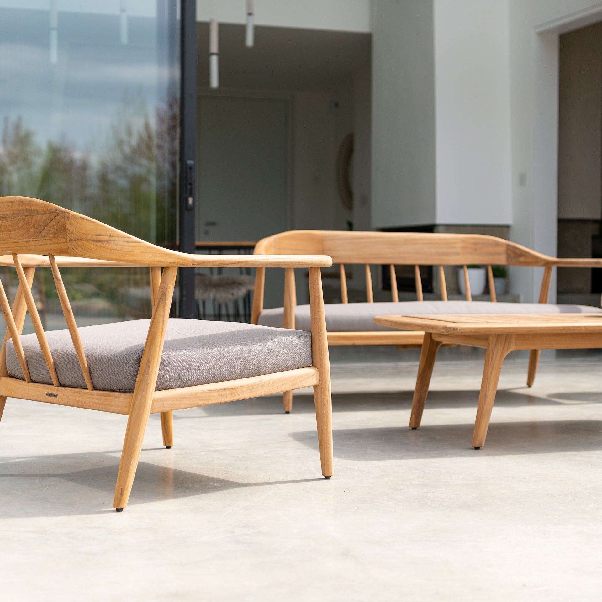 Teak outdoor lounge set with beautiful features, curved backs and grey seat covers