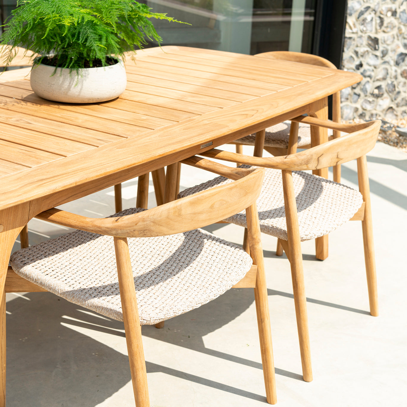 Wooden outdoor dining table with chairs on a patio