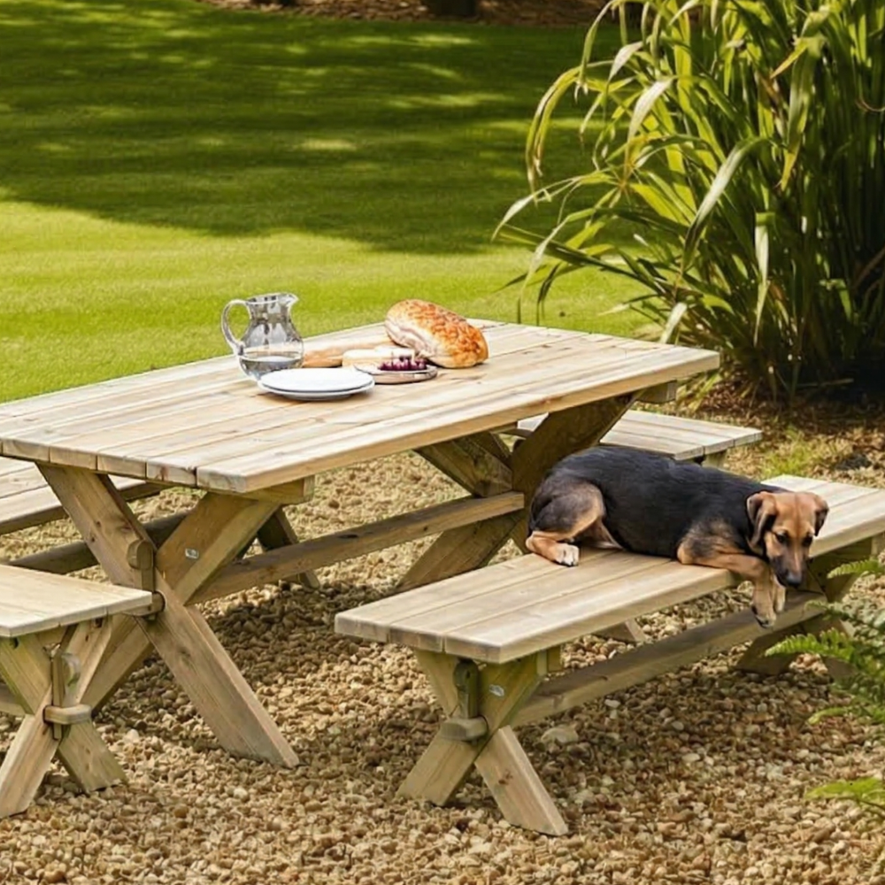 Wooden picnic table with a dog resting on a bench in a garden setting