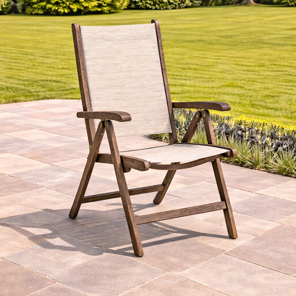 Beige and brown outdoor chair on a stone patio with green grass and bushes in the background
