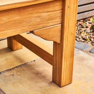 Close-up of a wooden bench on a stone patio