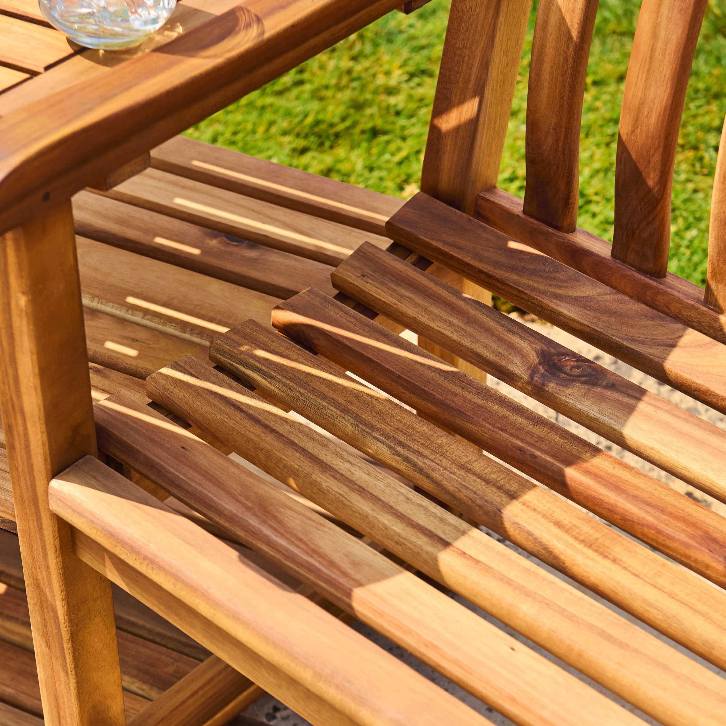 Close-up of a wooden chair with a blurred green outdoor background