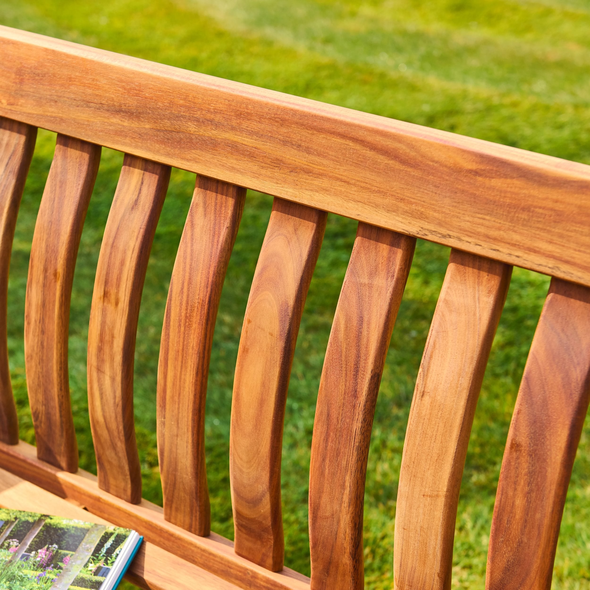 Wooden bench with a blurred green grass background