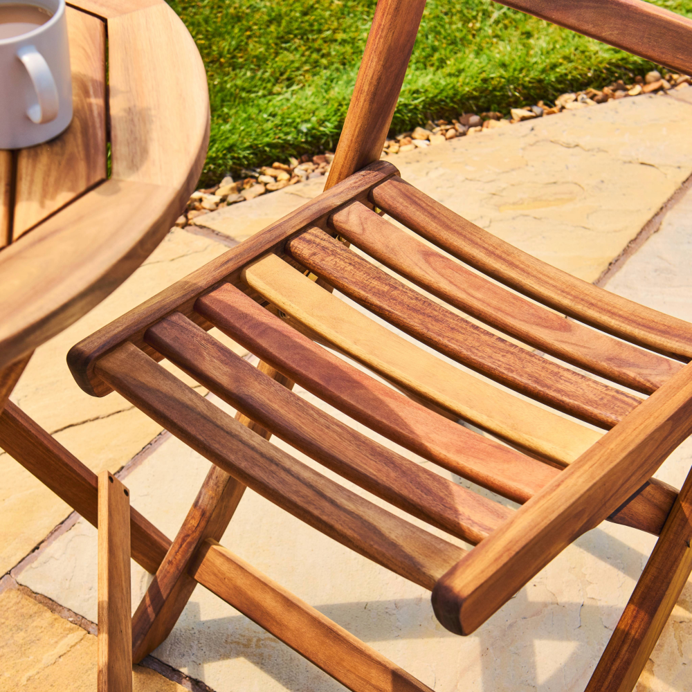 Wooden folding stool on a patio with a blurred background