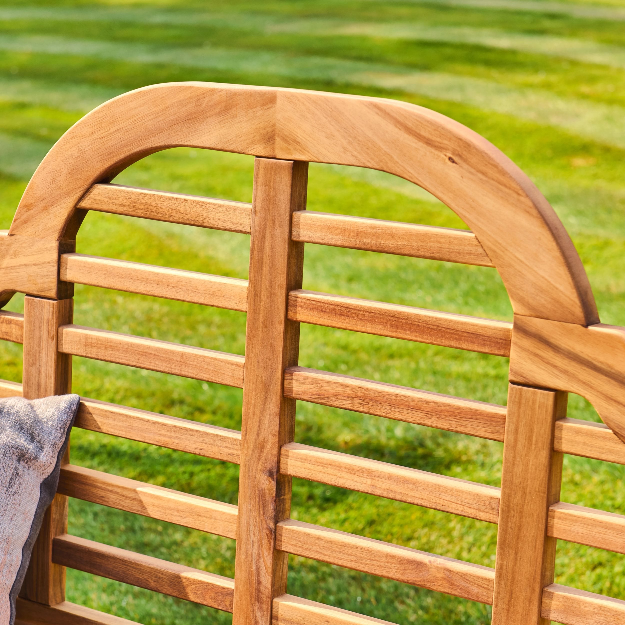 Wooden outdoor chair with a blurred green lawn background