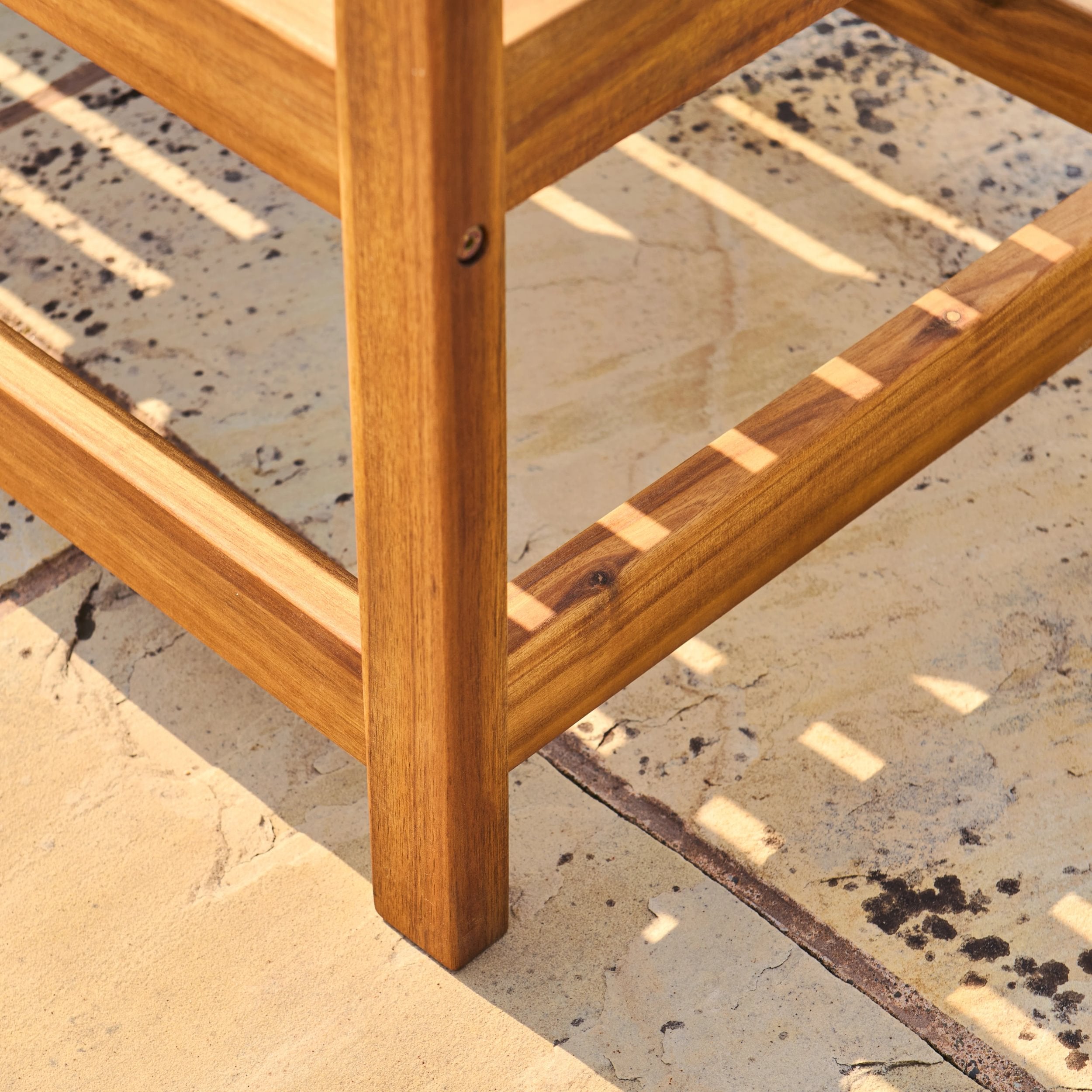 Close-up of a wooden chair leg on a stone floor