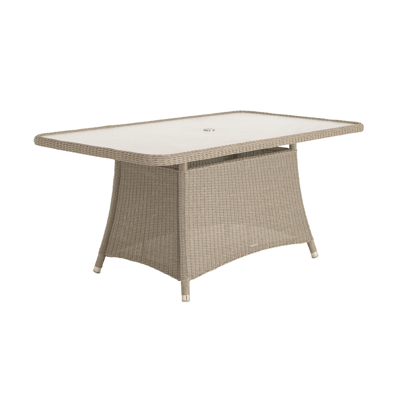 Rectangular outdoor table with wicker frame and glass top on a white background