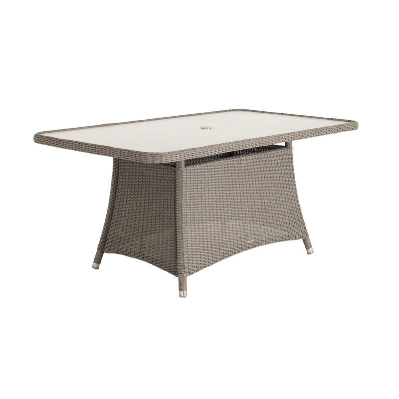 Rectangular outdoor table with wicker frame and glass top on a white background