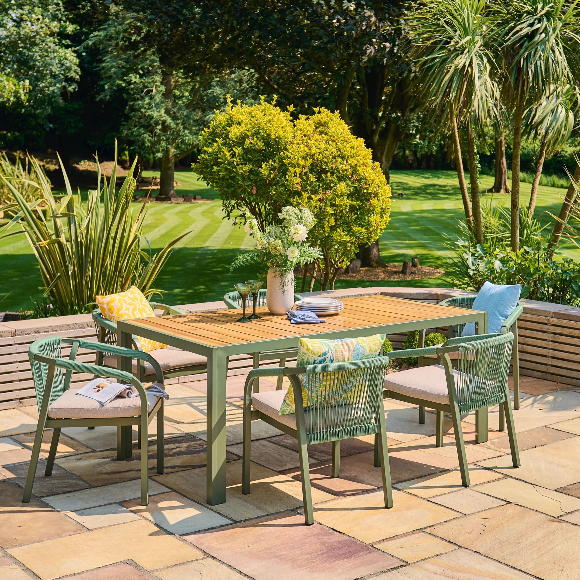 Outdoor patio set with table and chairs in a garden setting