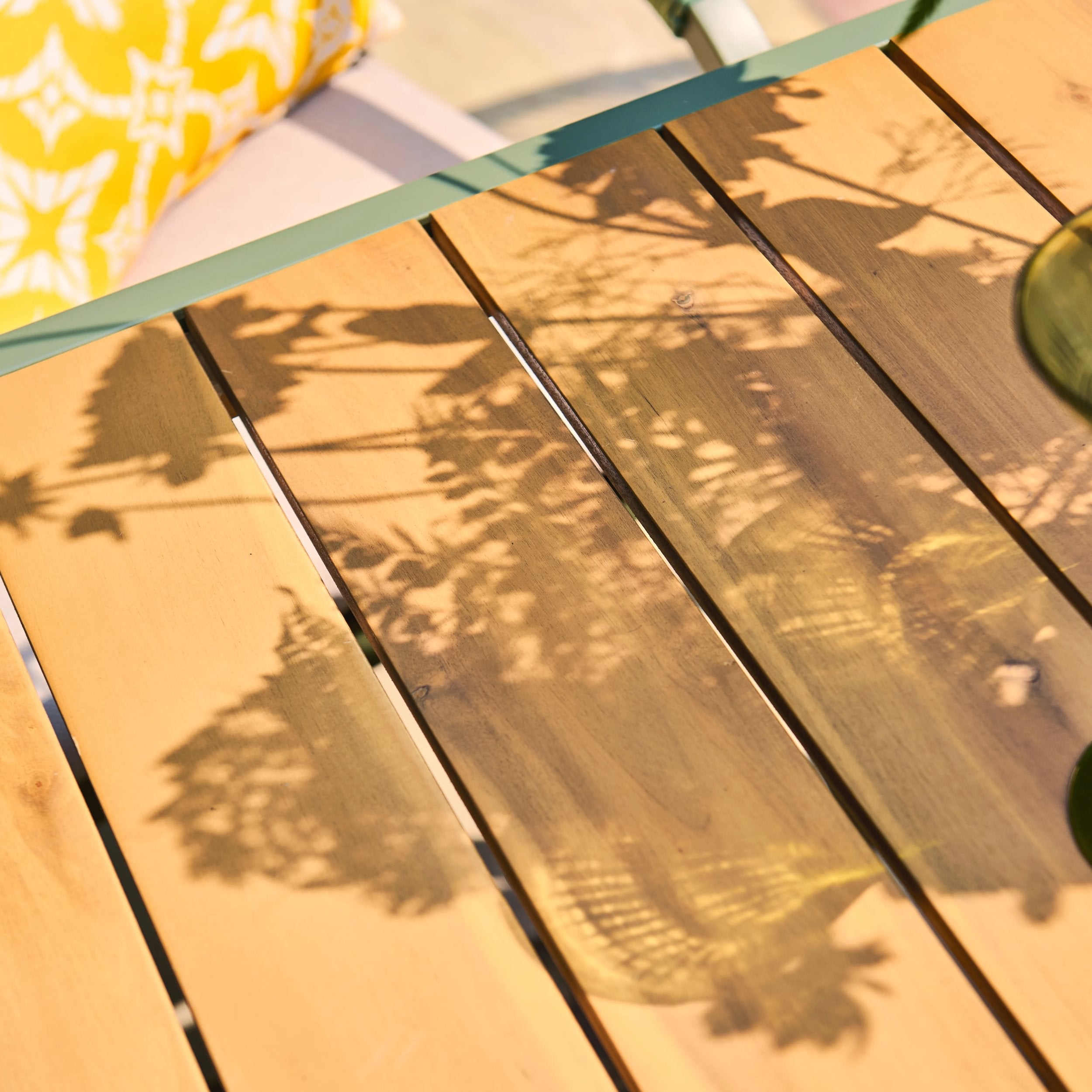 Close-up of a timber table top with shadows cast by leaves