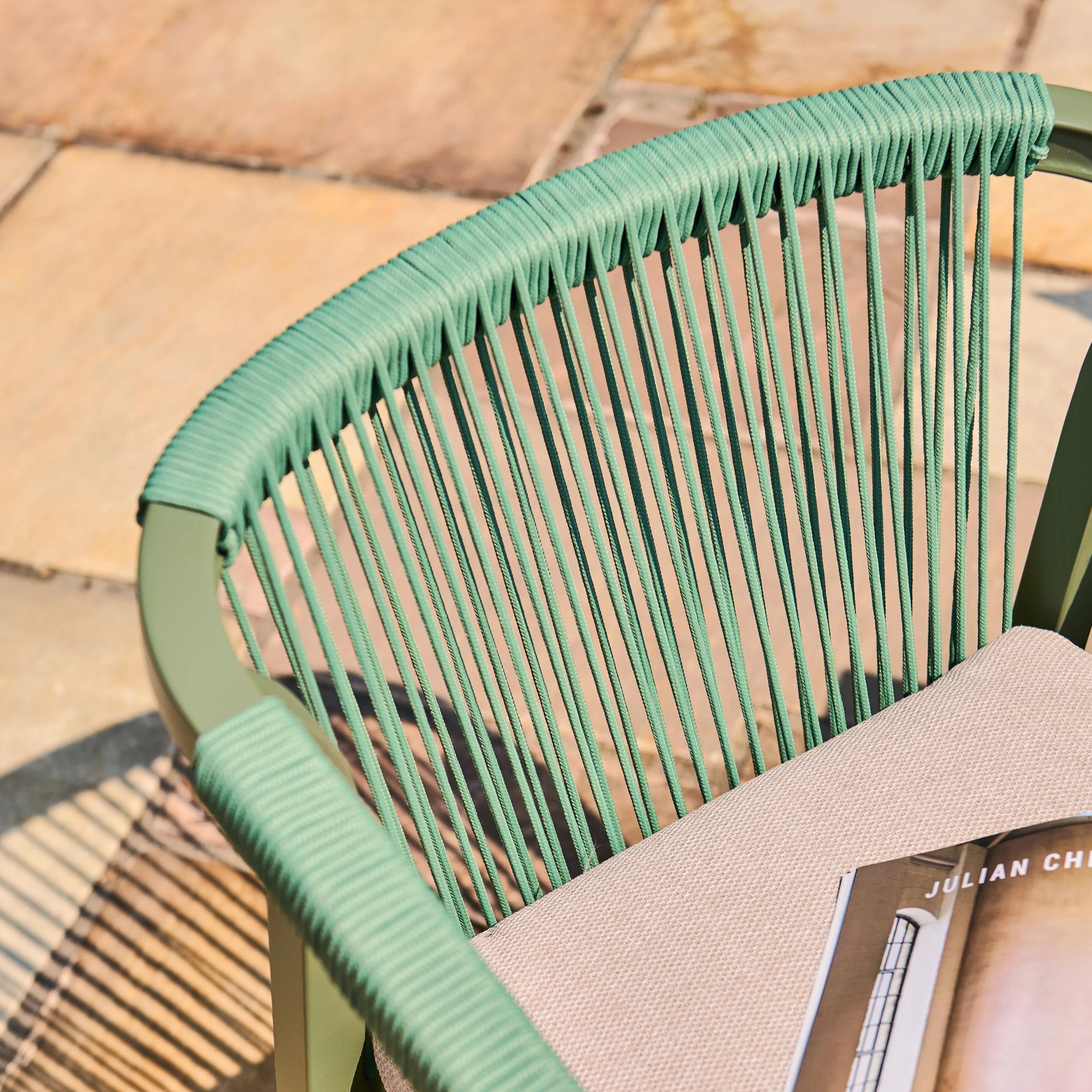 Close-up of a green woven chair with a blurred background