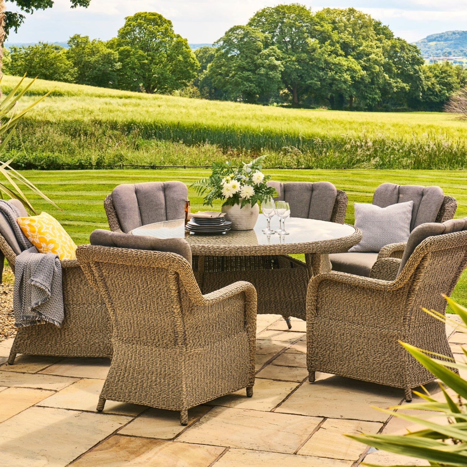 Outdoor patio set with round table and chairs in a garden setting