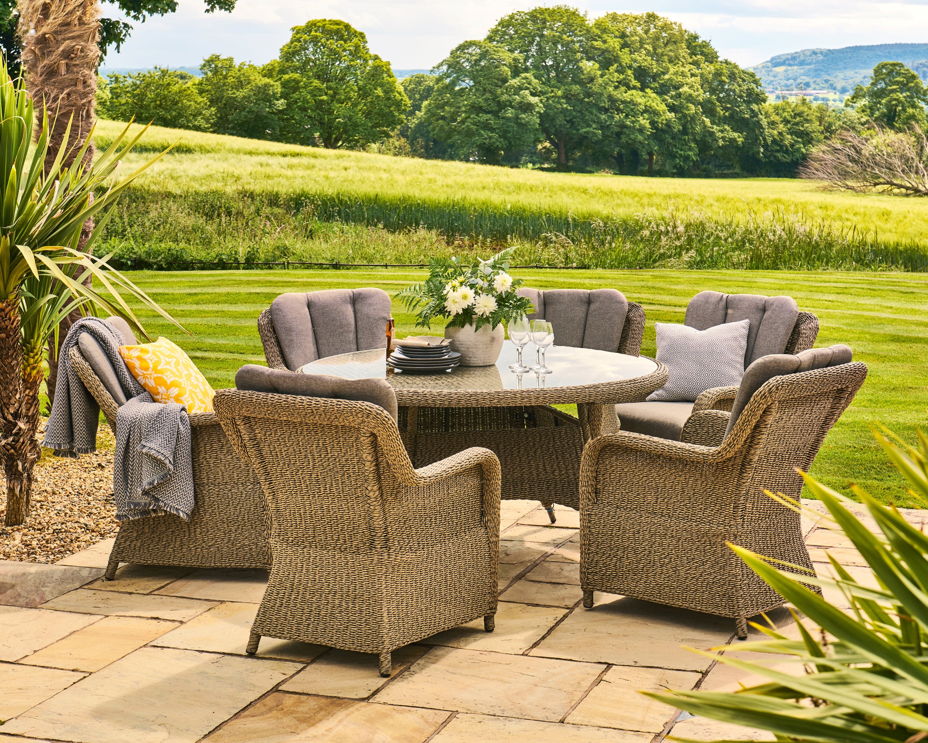 Outdoor patio set with round table and chairs in a garden setting
