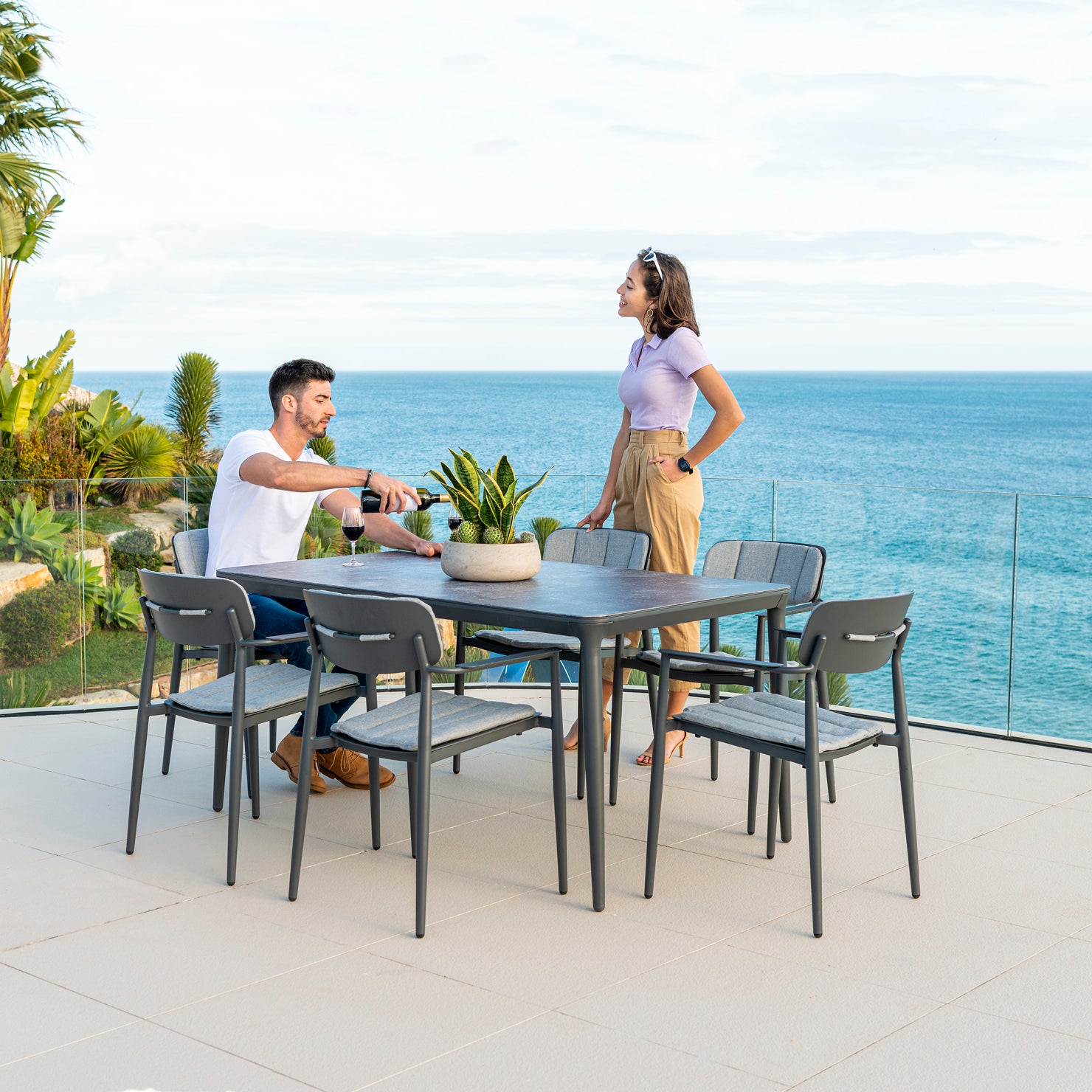 Two people sitting at a dining table with a scenic ocean view.