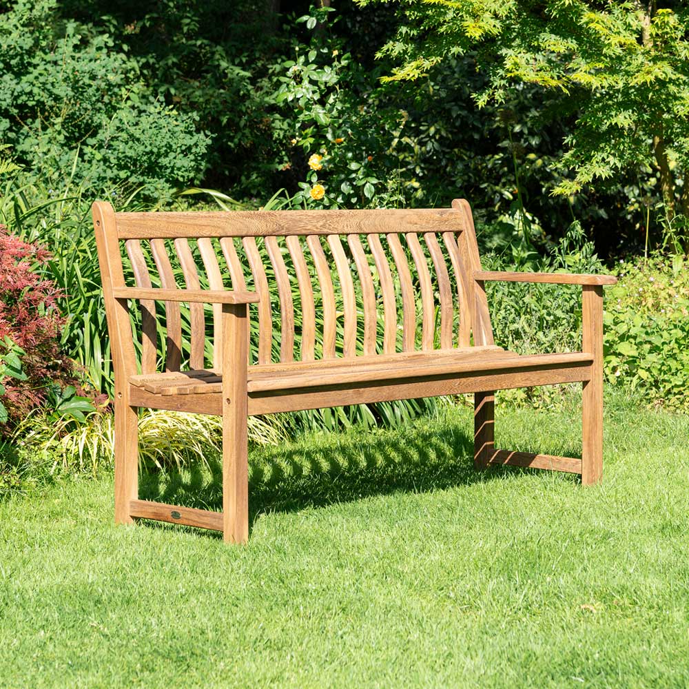 Albany Broadfield Bench Wooden bench in a garden setting with greenery