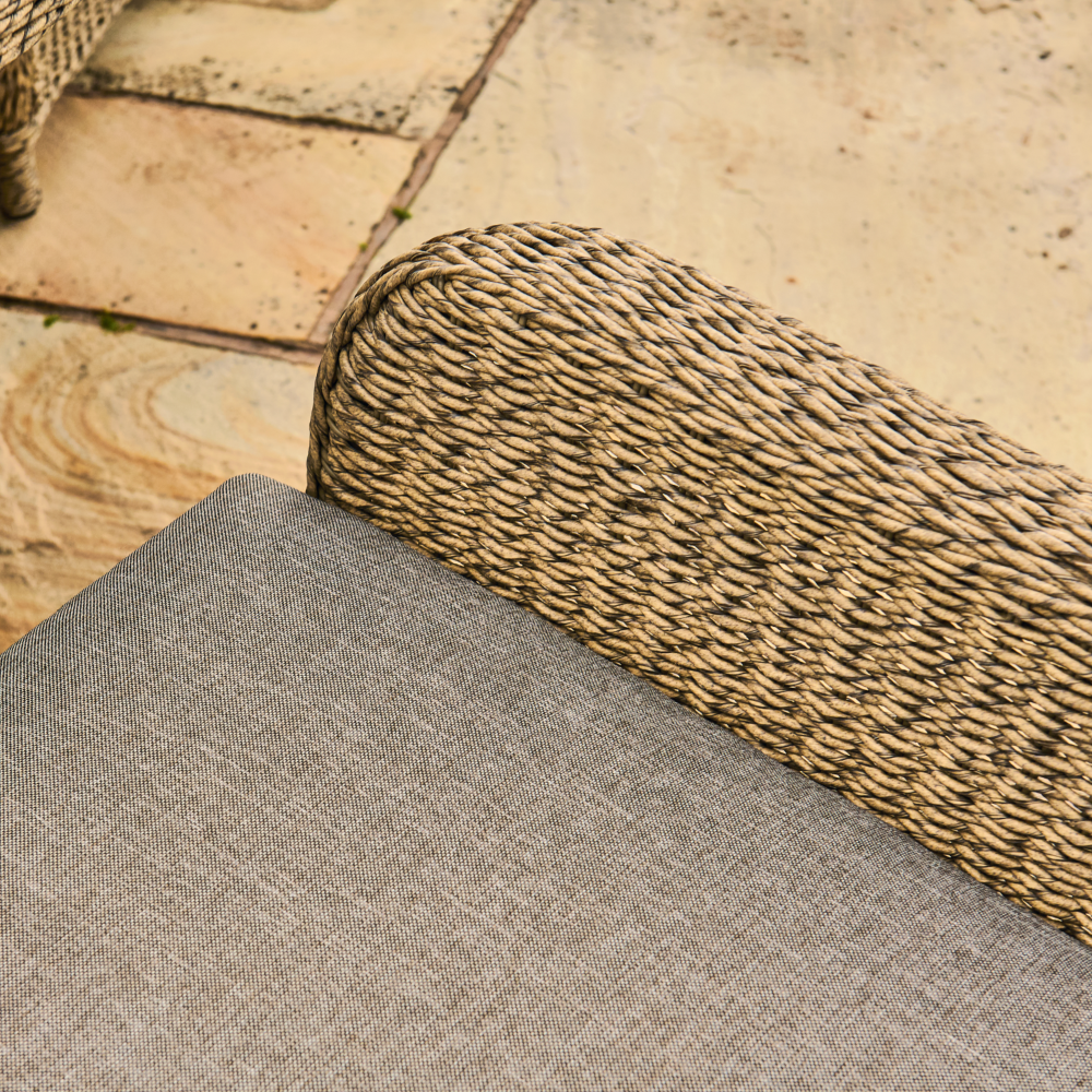 Close-up of textured gray fabric and woven brown material on a stone surface