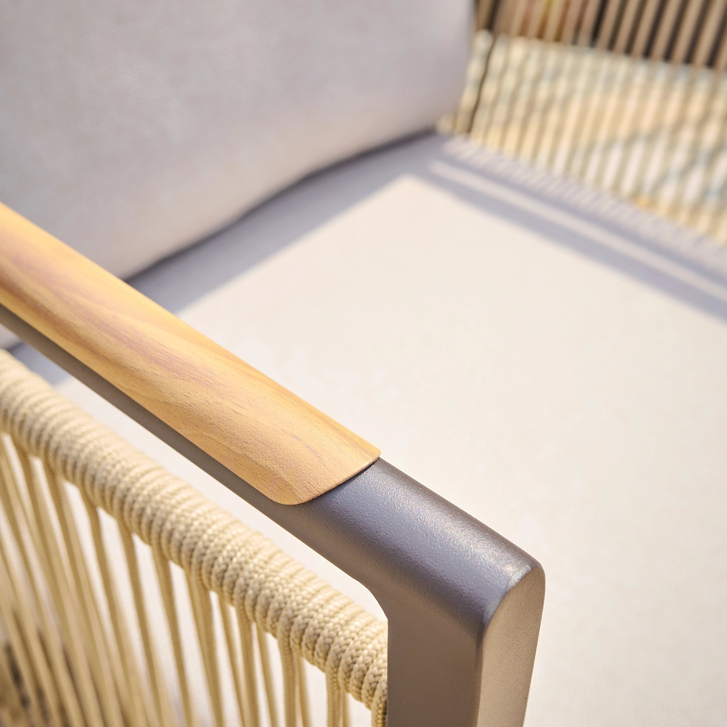 Close-up of a chair with wooden armrest and metal frame