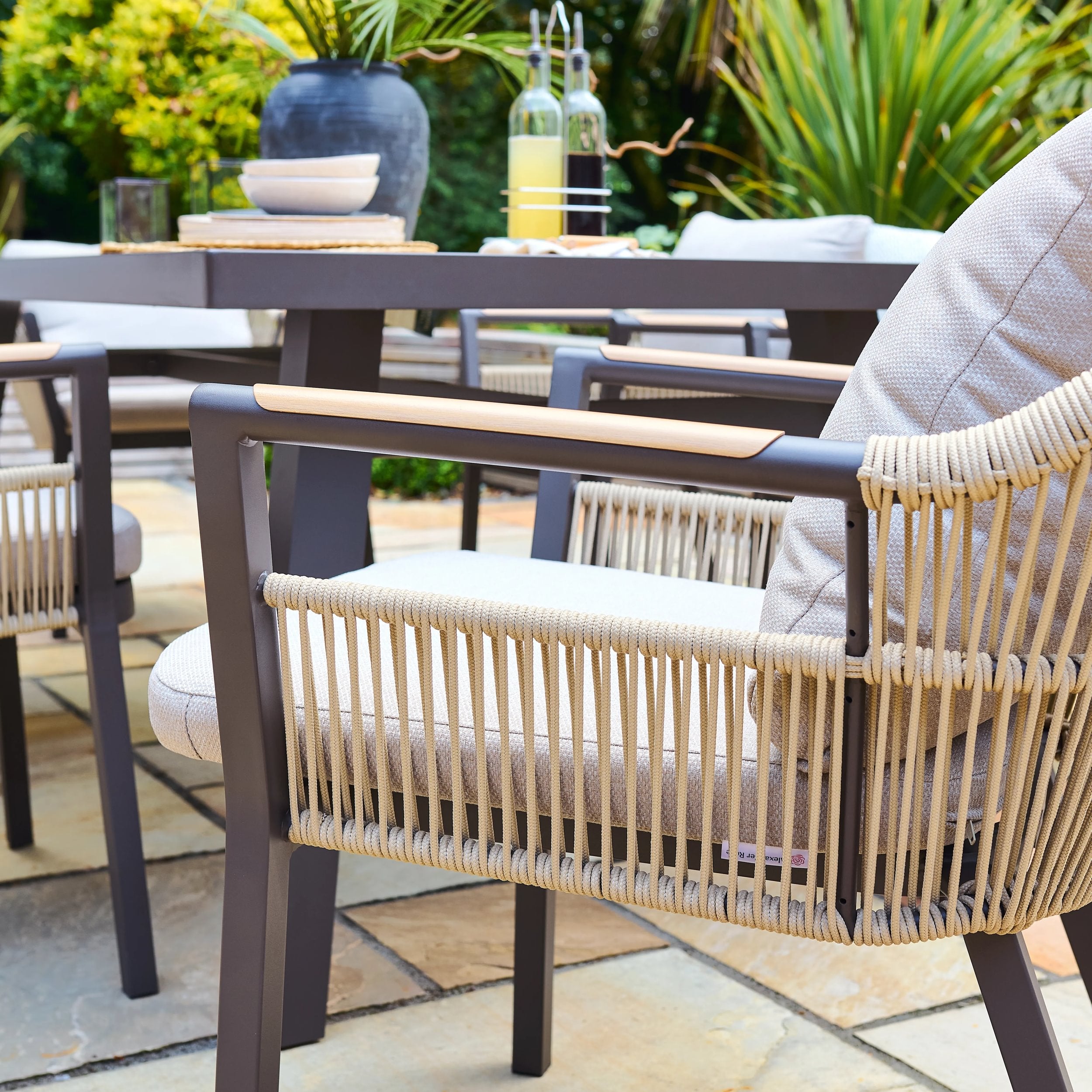 Outdoor patio setting with woven rope chair and table in a garden setting