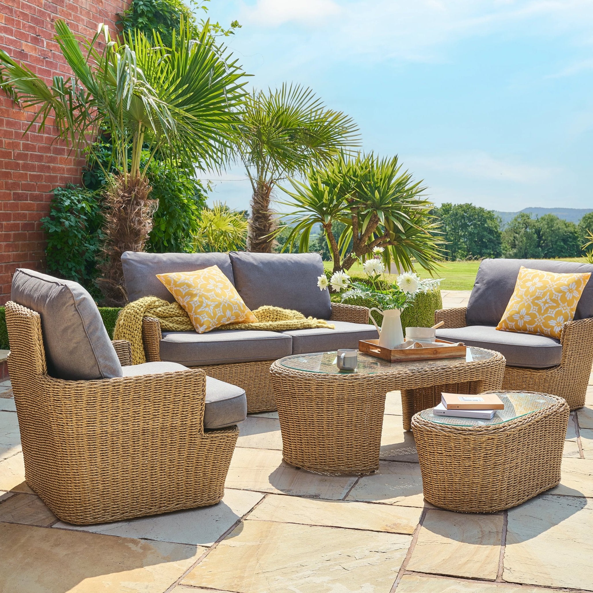 Outdoor patio set with furniture and decor on a stone patio.