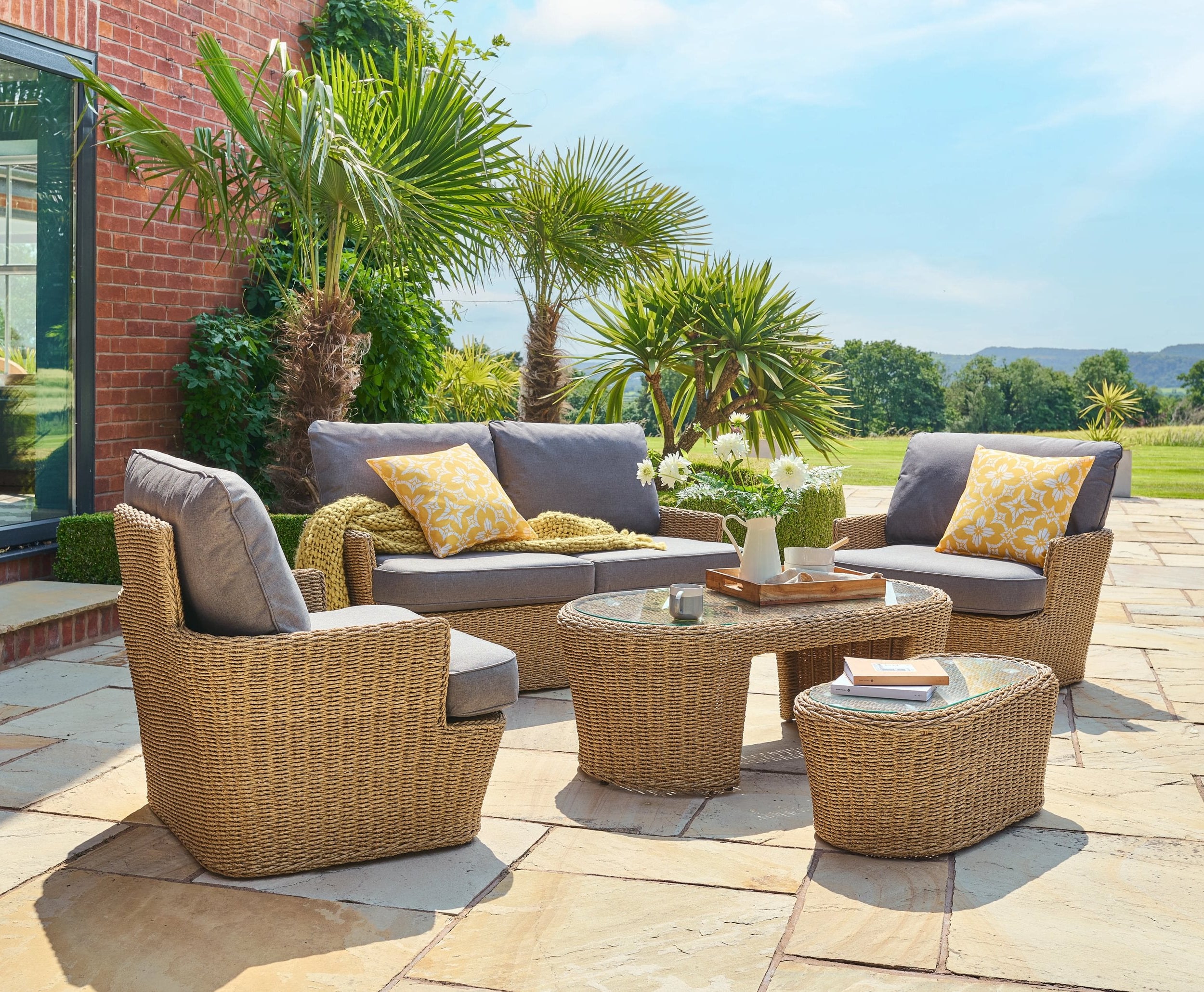 Outdoor patio set with furniture and decor on a stone patio.