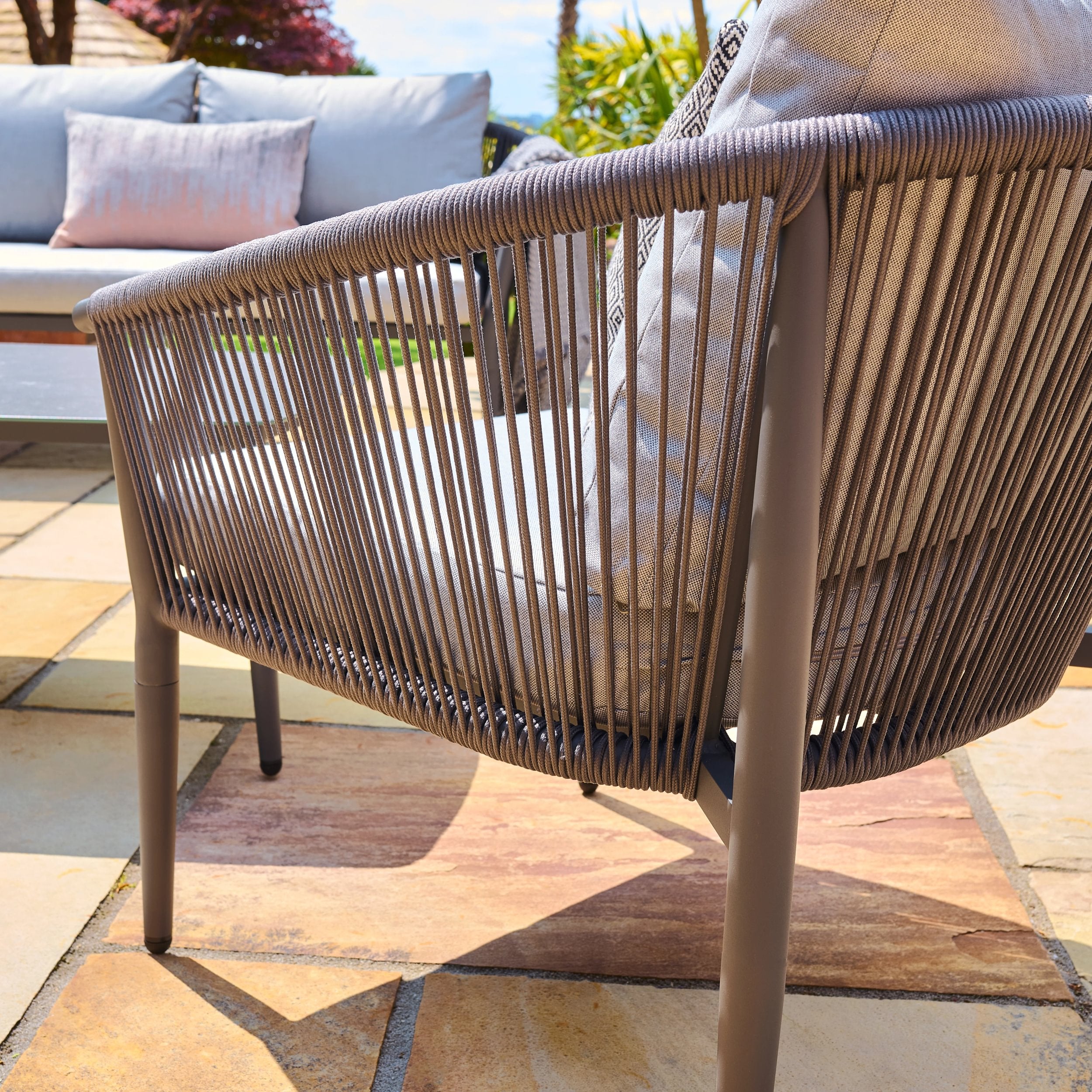 Woven chair on a patio with outdoor furniture in the background