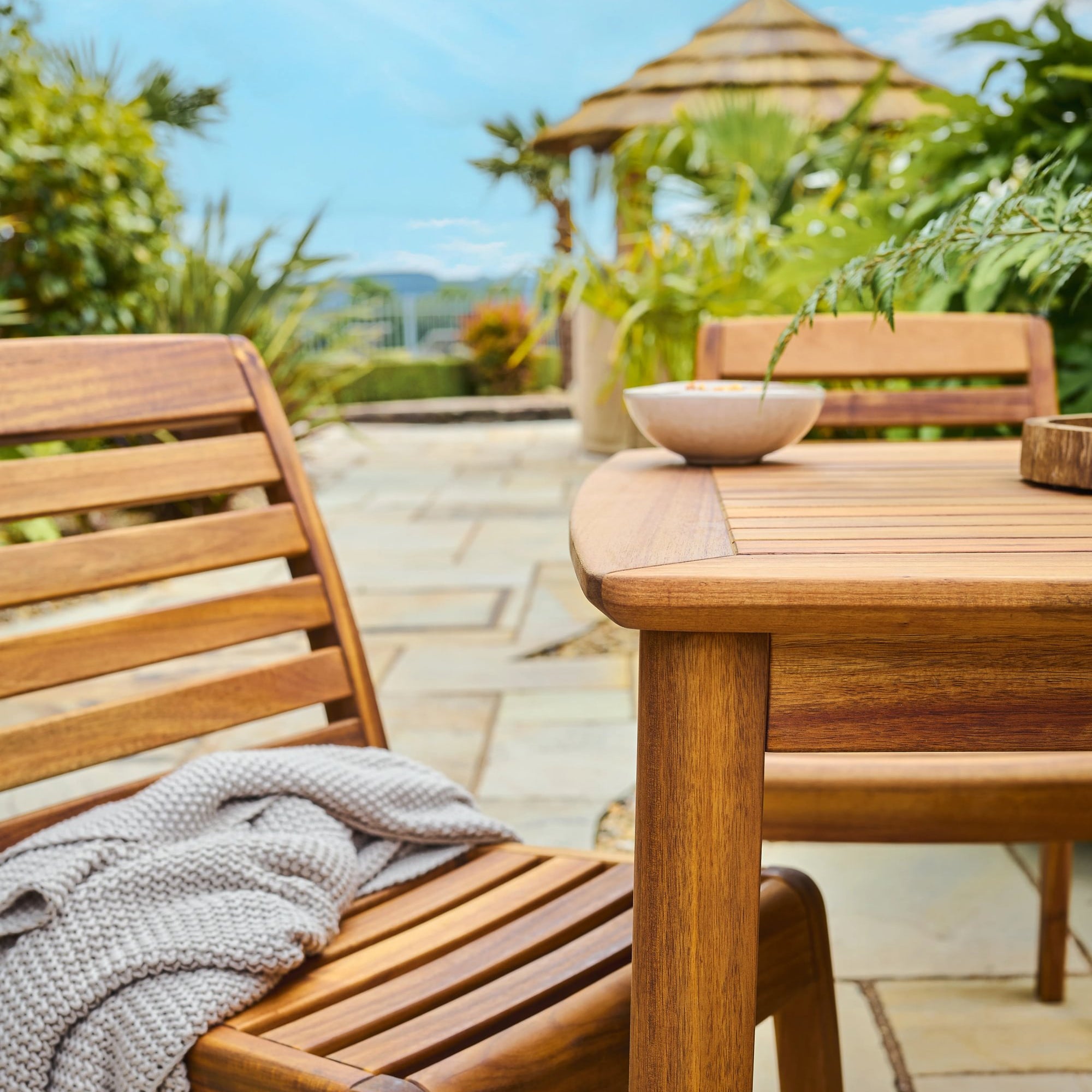 Wooden outdoor furniture set with a table and chairs on a patio