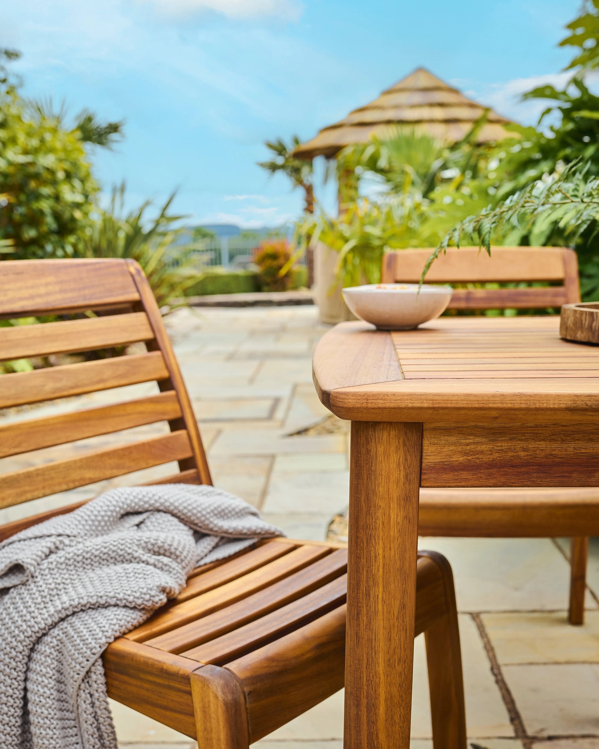 Wooden outdoor furniture set with a table and chairs on a patio