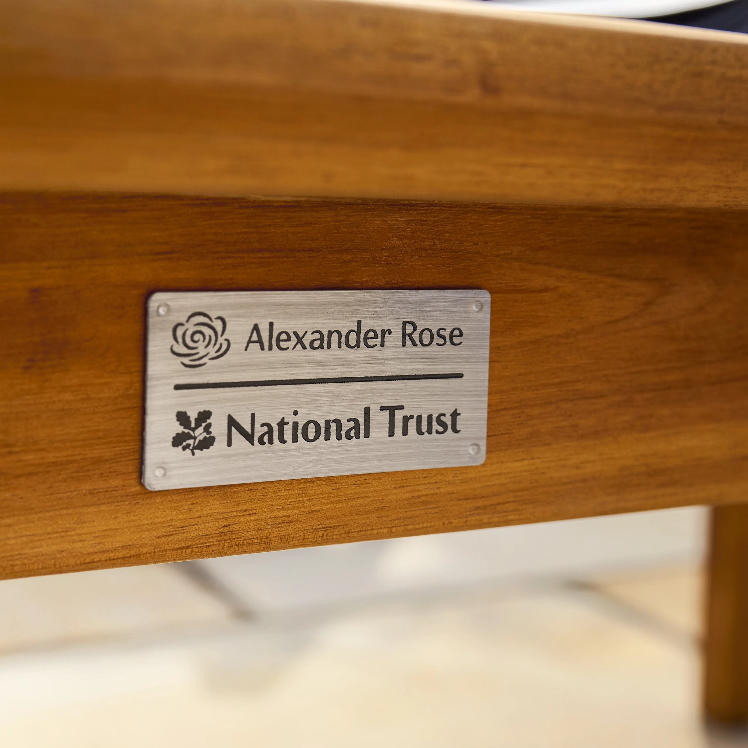 Wooden furniture with a metal plaque featuring 'Alexander Rose' and 'National Trust'