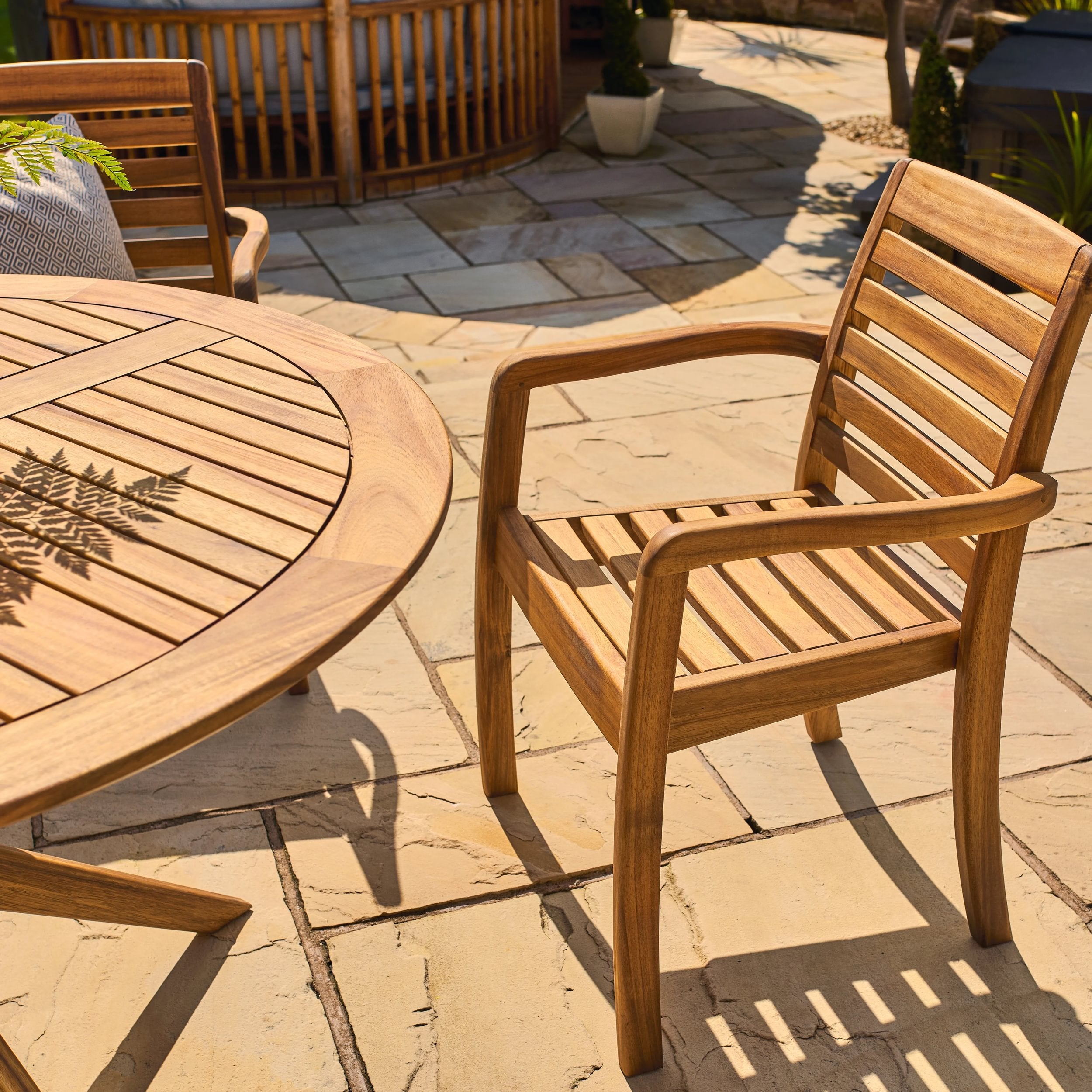 Wooden outdoor furniture set on a stone patio