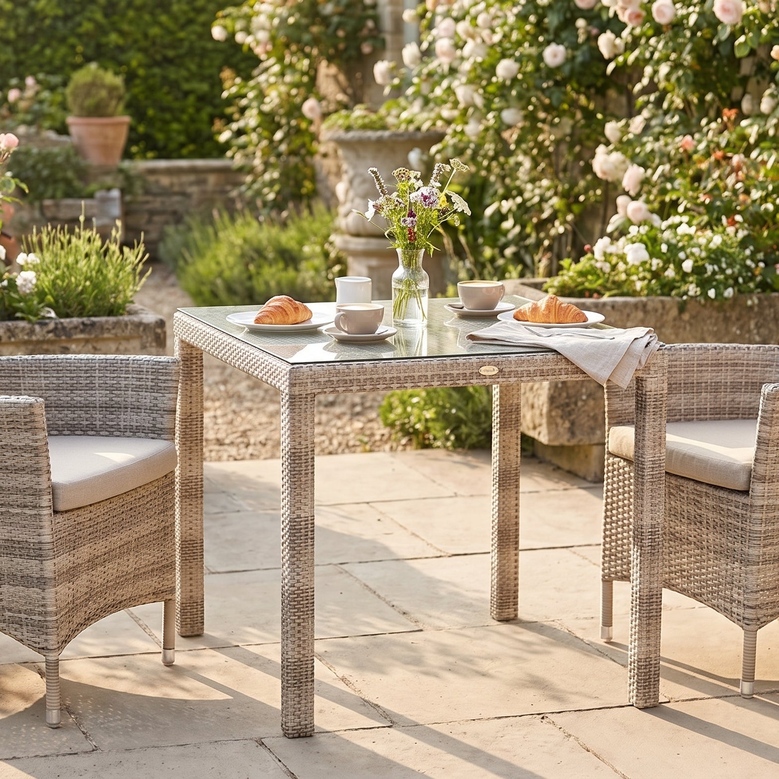 Outdoor patio set with table and chairs in a garden setting