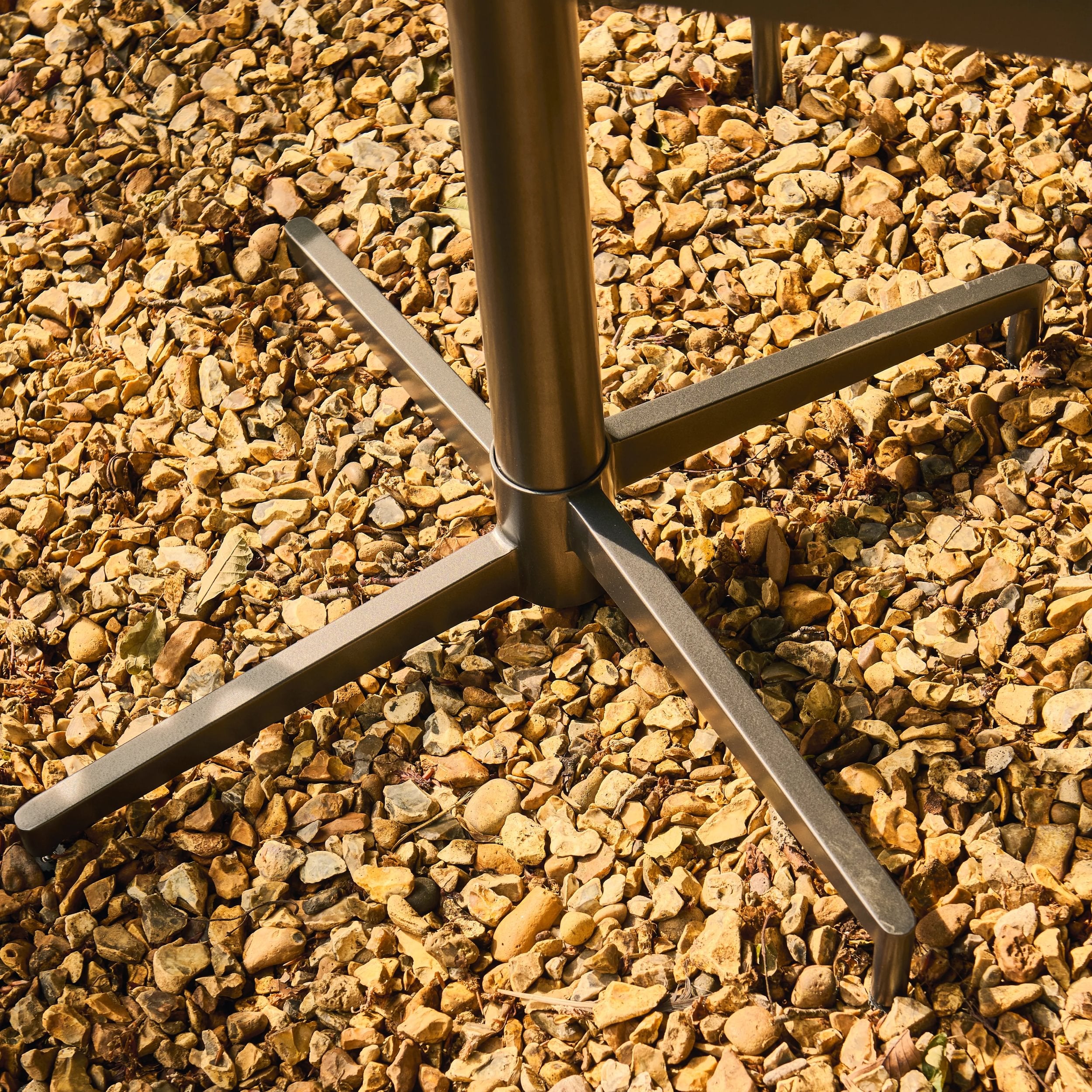 Metal stand on a bed of small stones
