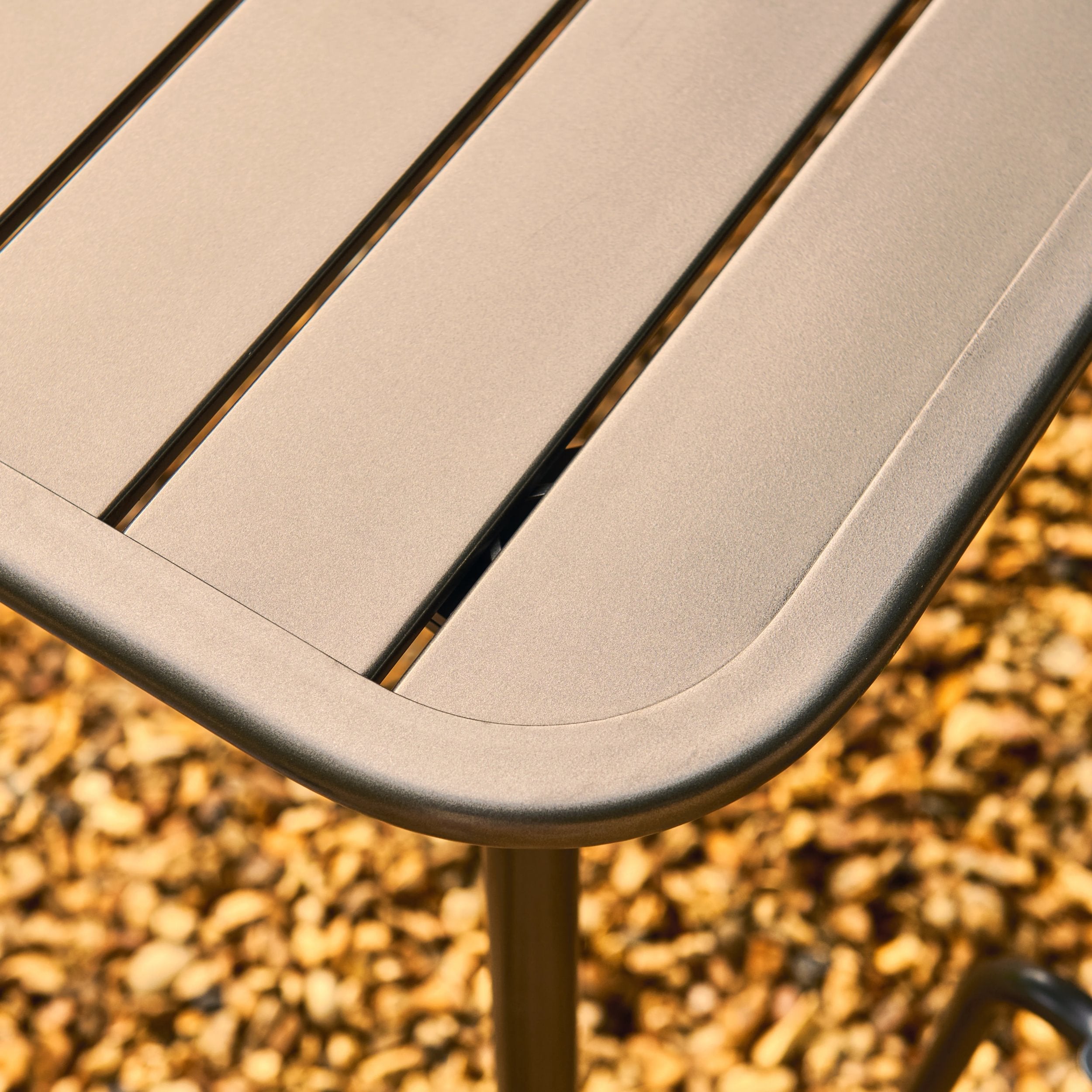 Close-up of a metal outdoor table with a blurred natural background