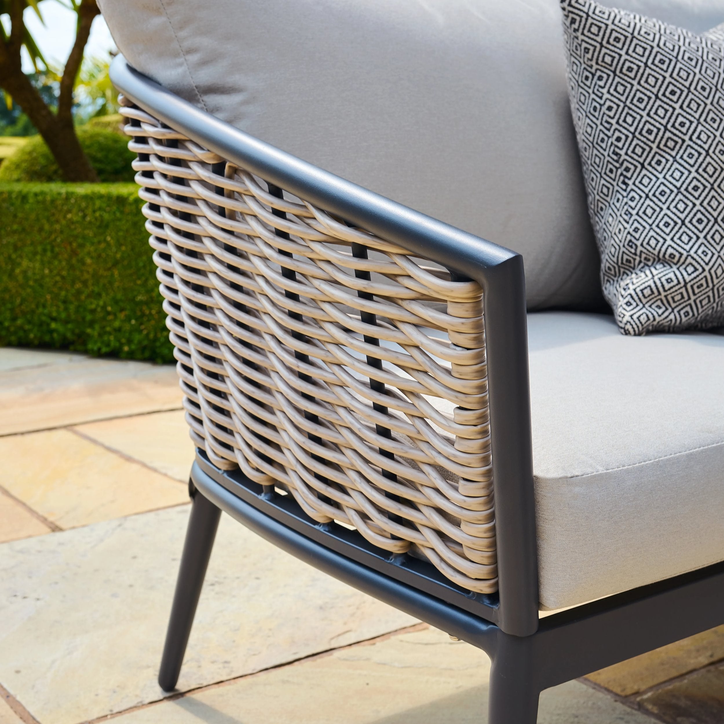 Outdoor furniture with wicker backrest and cushions on a patio