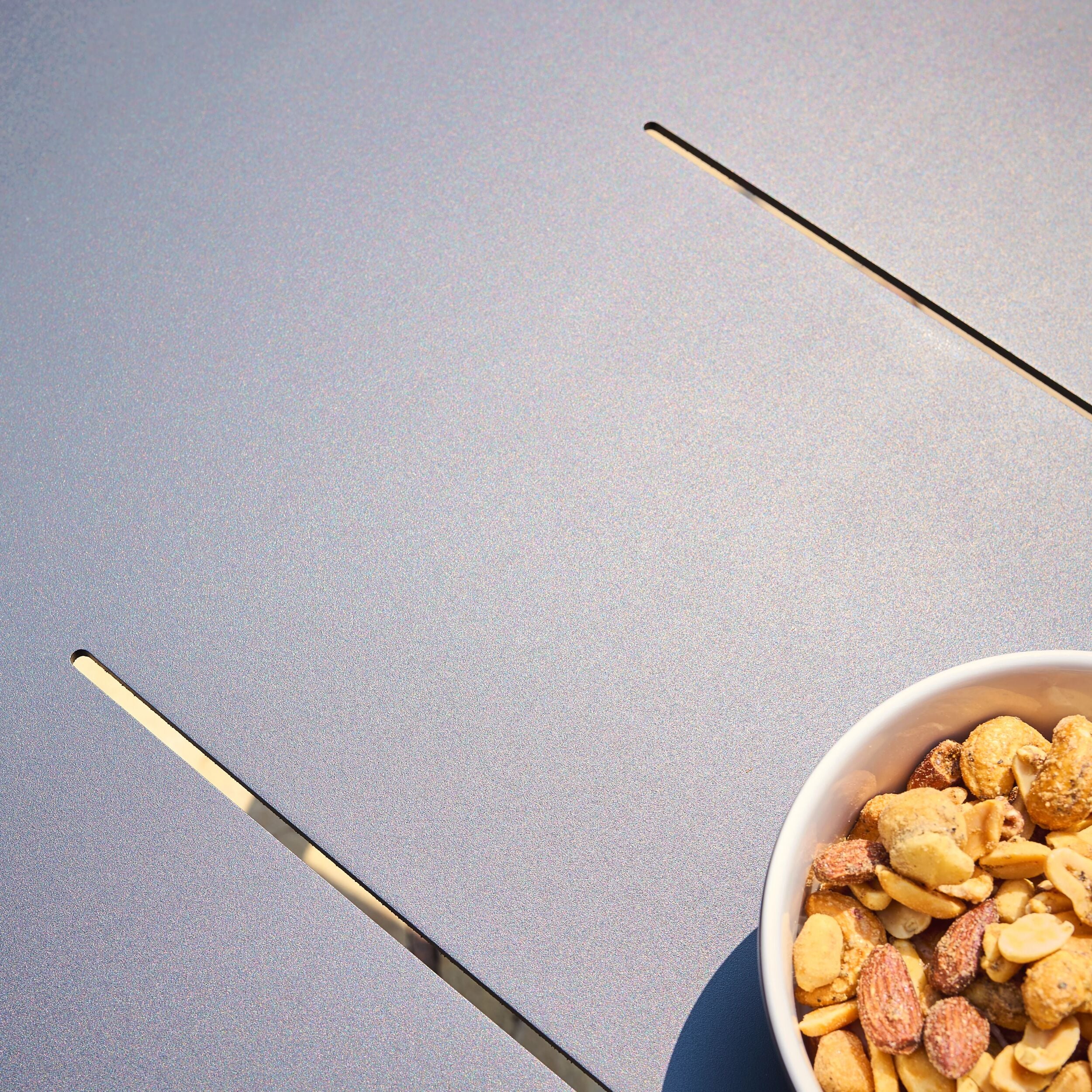 Bowl of mixed nuts on a light grey surface
