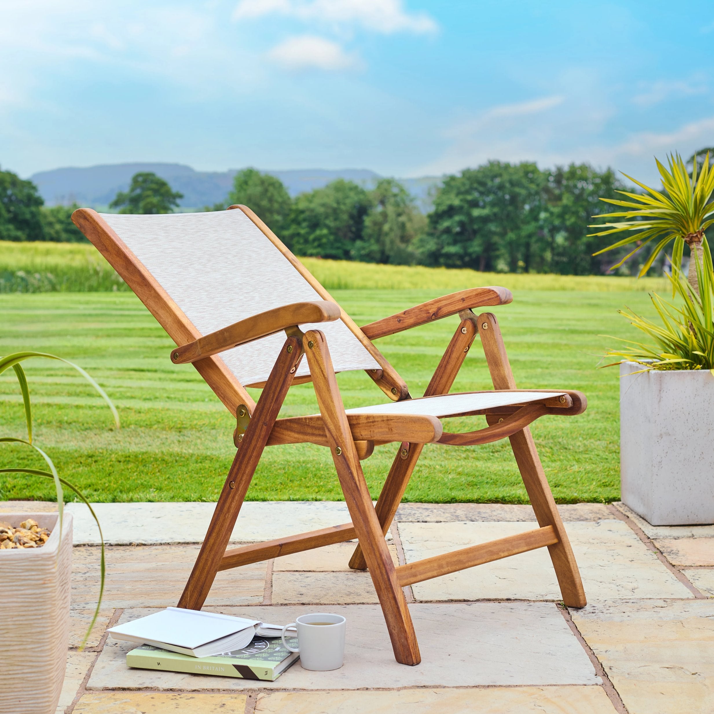 Wooden deck chair on a patio with a scenic background