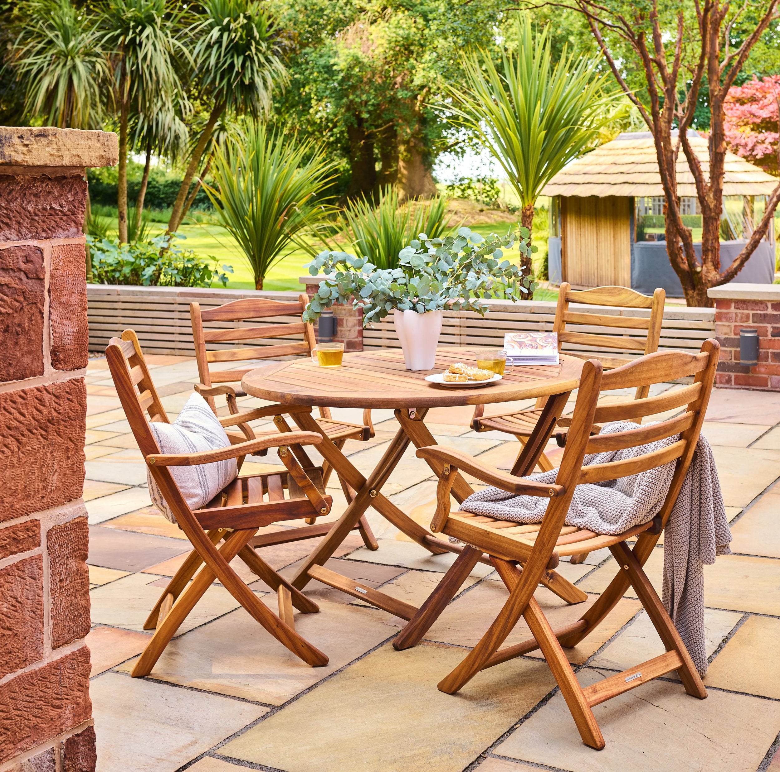 Wooden outdoor dining set with table and chairs on a patio