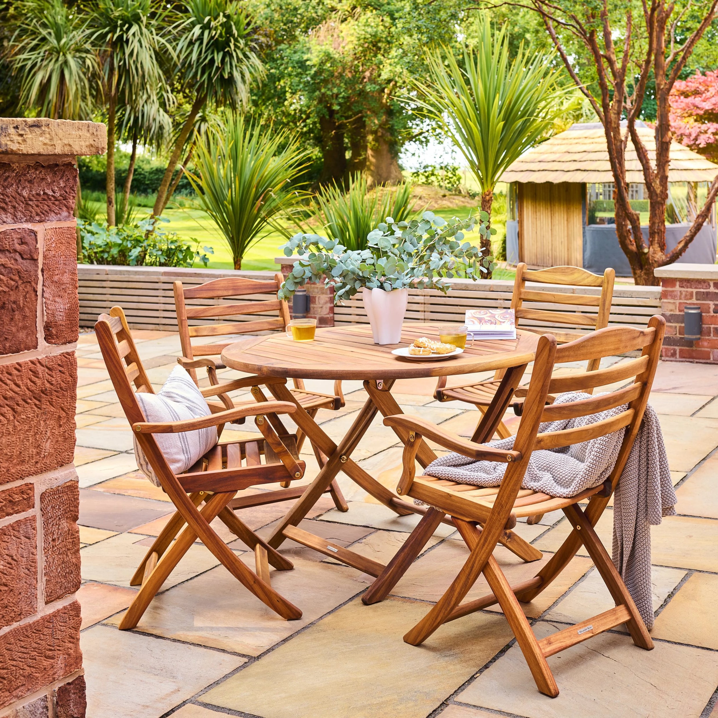 Wooden outdoor dining set with table and chairs on a patio