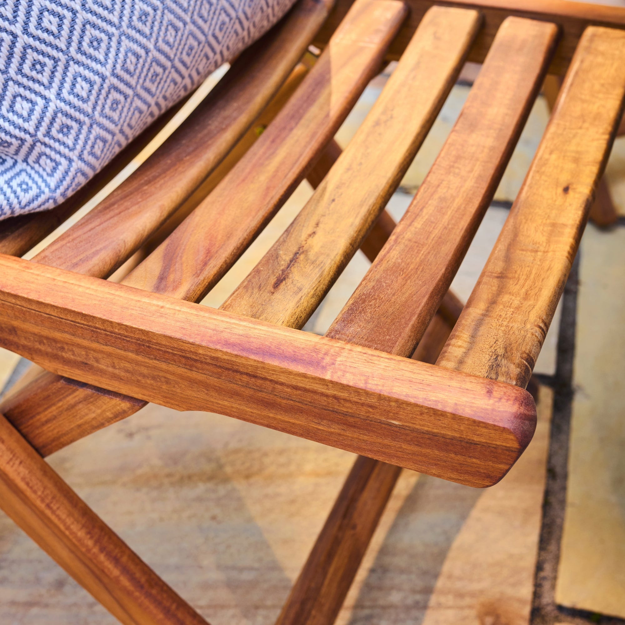 Close-up of a wooden chair with a patterned cushion