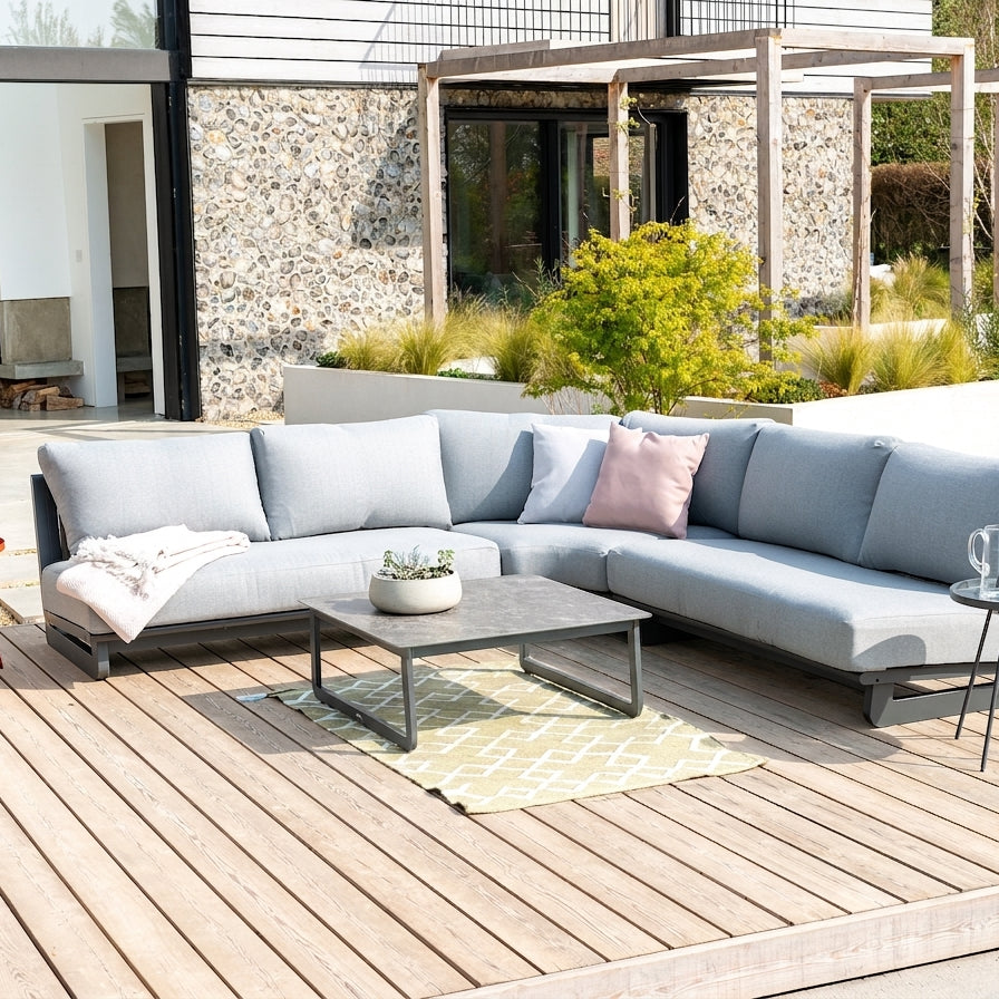 RIMINI GREY MODULAR CORNER SOFA WITH COFFEE TABLE ON A PATIO SETTING