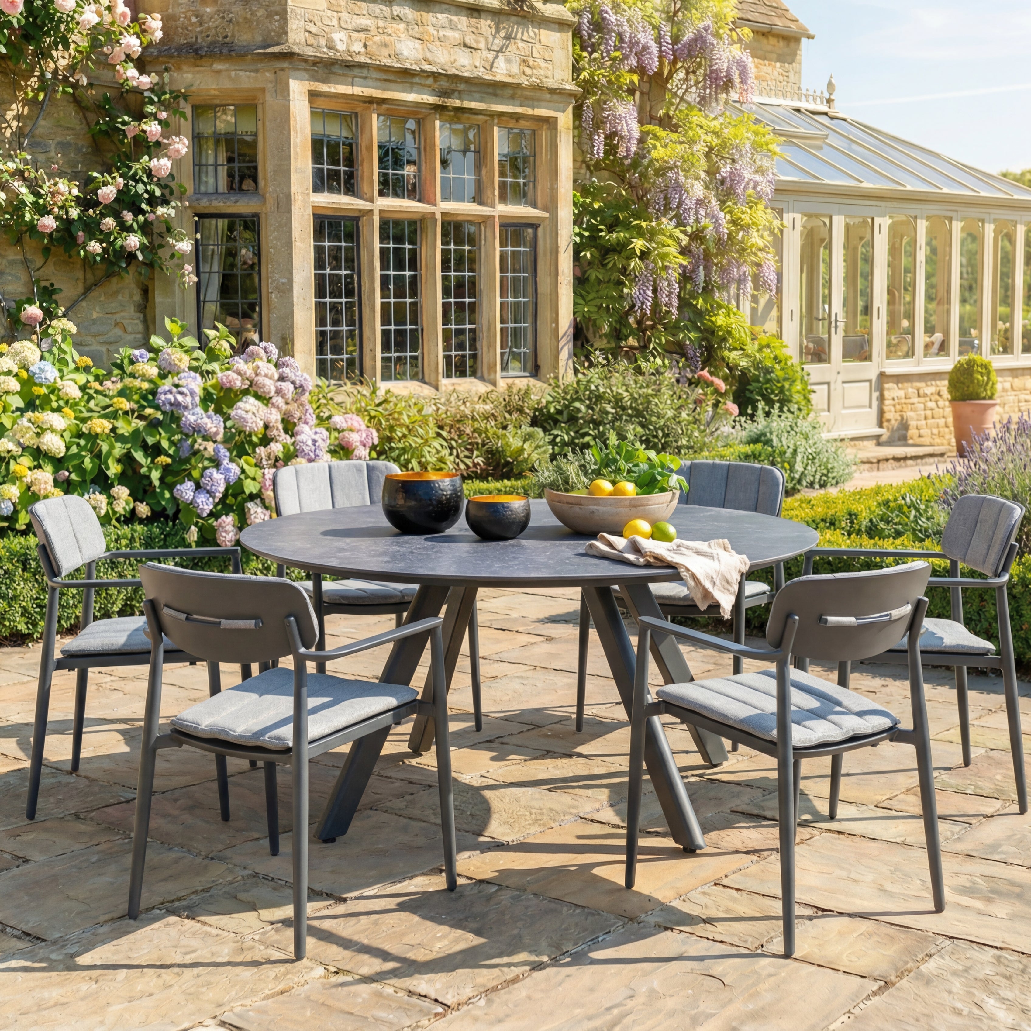 Outdoor patio set with round dining table and chairs in a garden setting