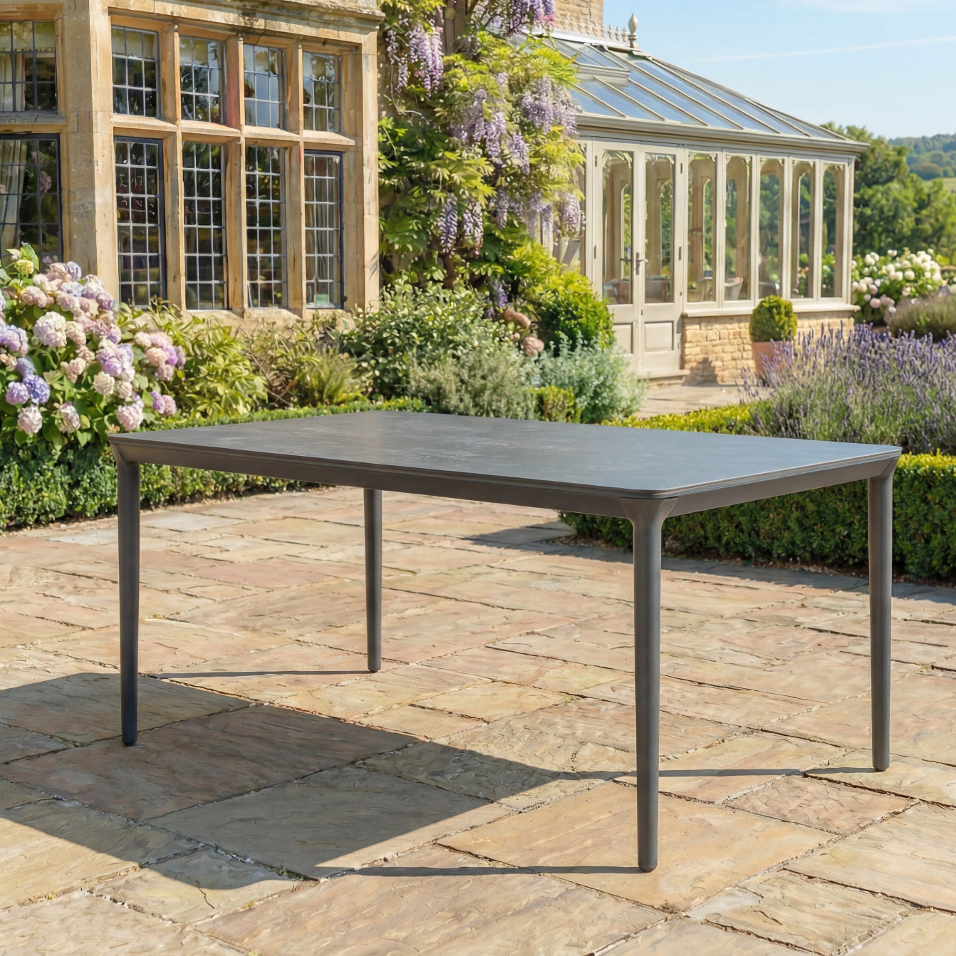 Garden table on a patio with a garden and building in the background