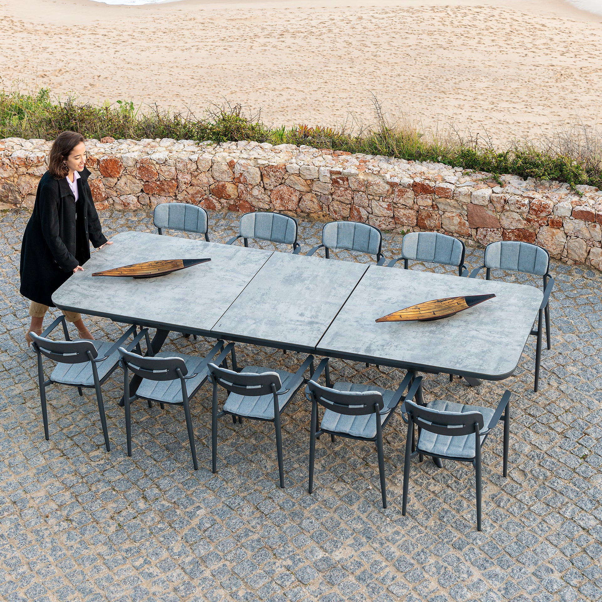 Rimini extending outdoor dining table and 10 matching chairs on a patio