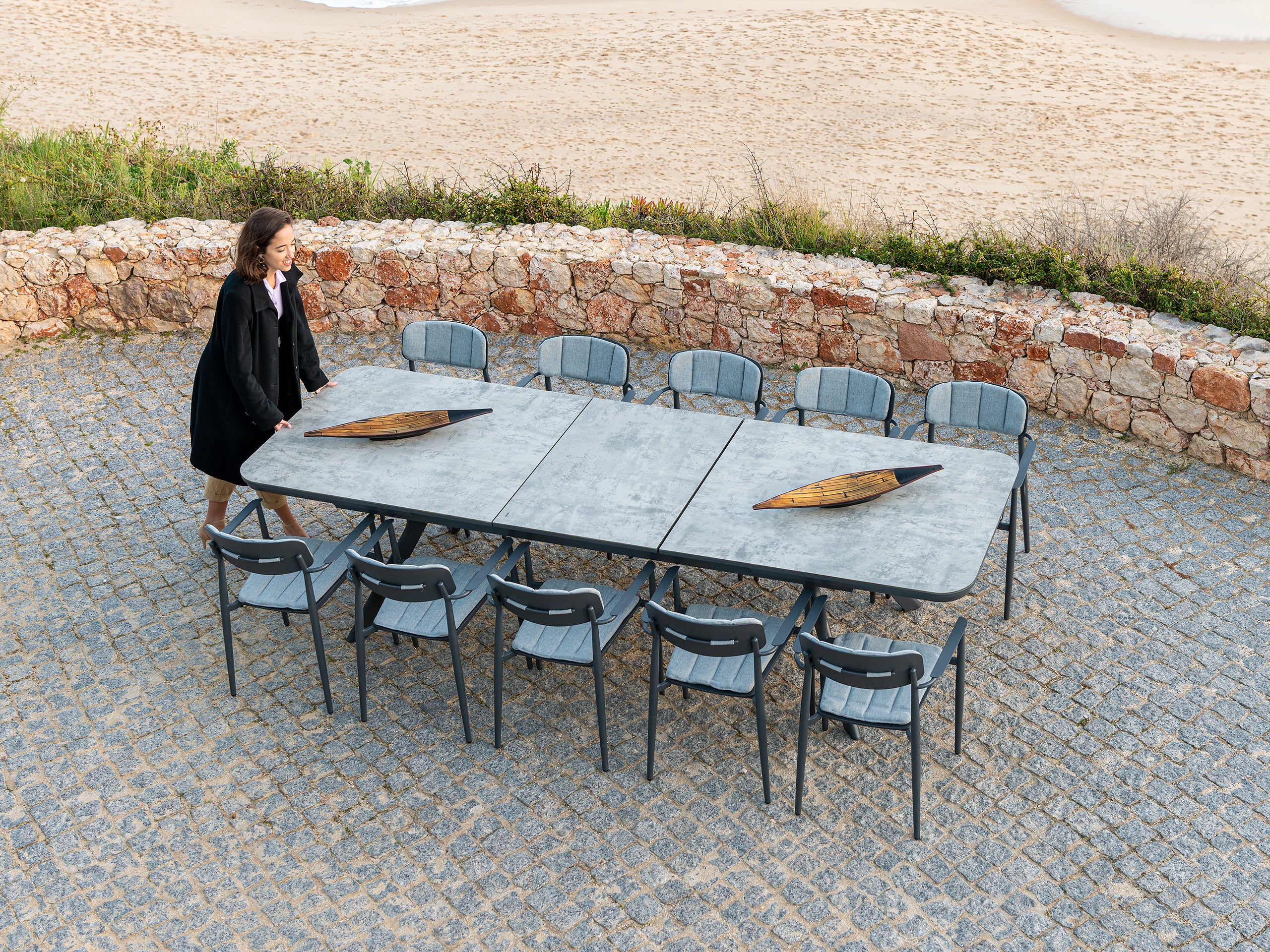 Rimini extending outdoor dining table and 10 matching chairs on a patio